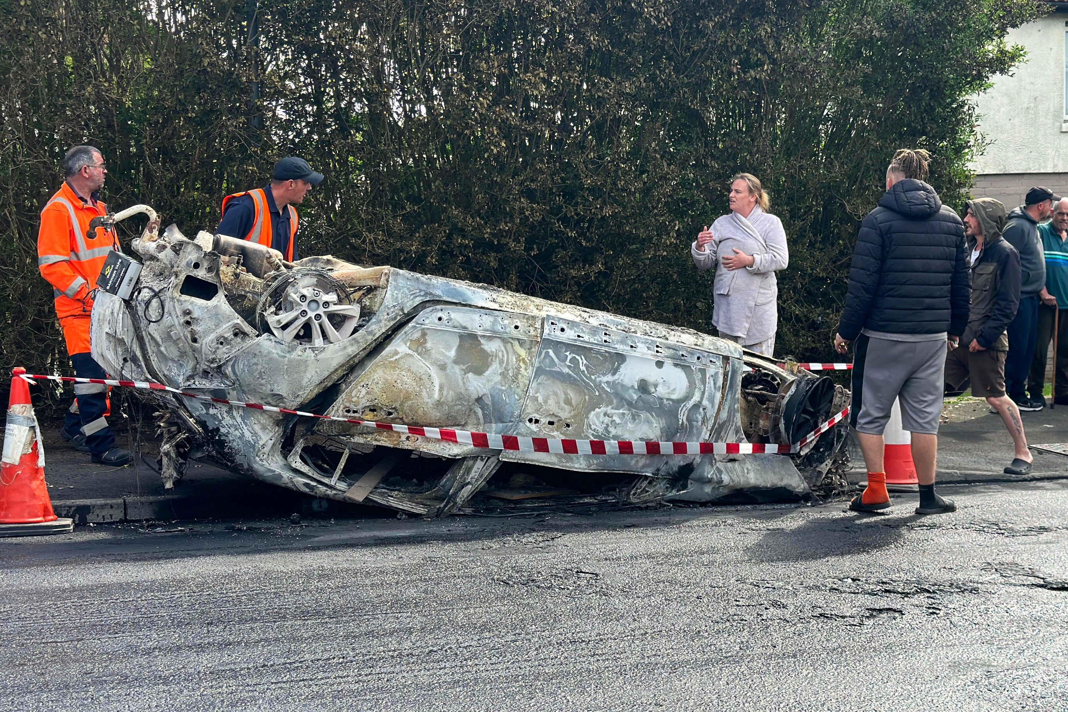 Council workers secure the area immediately around a car that was set alight in Ely, Cardiff (PA)