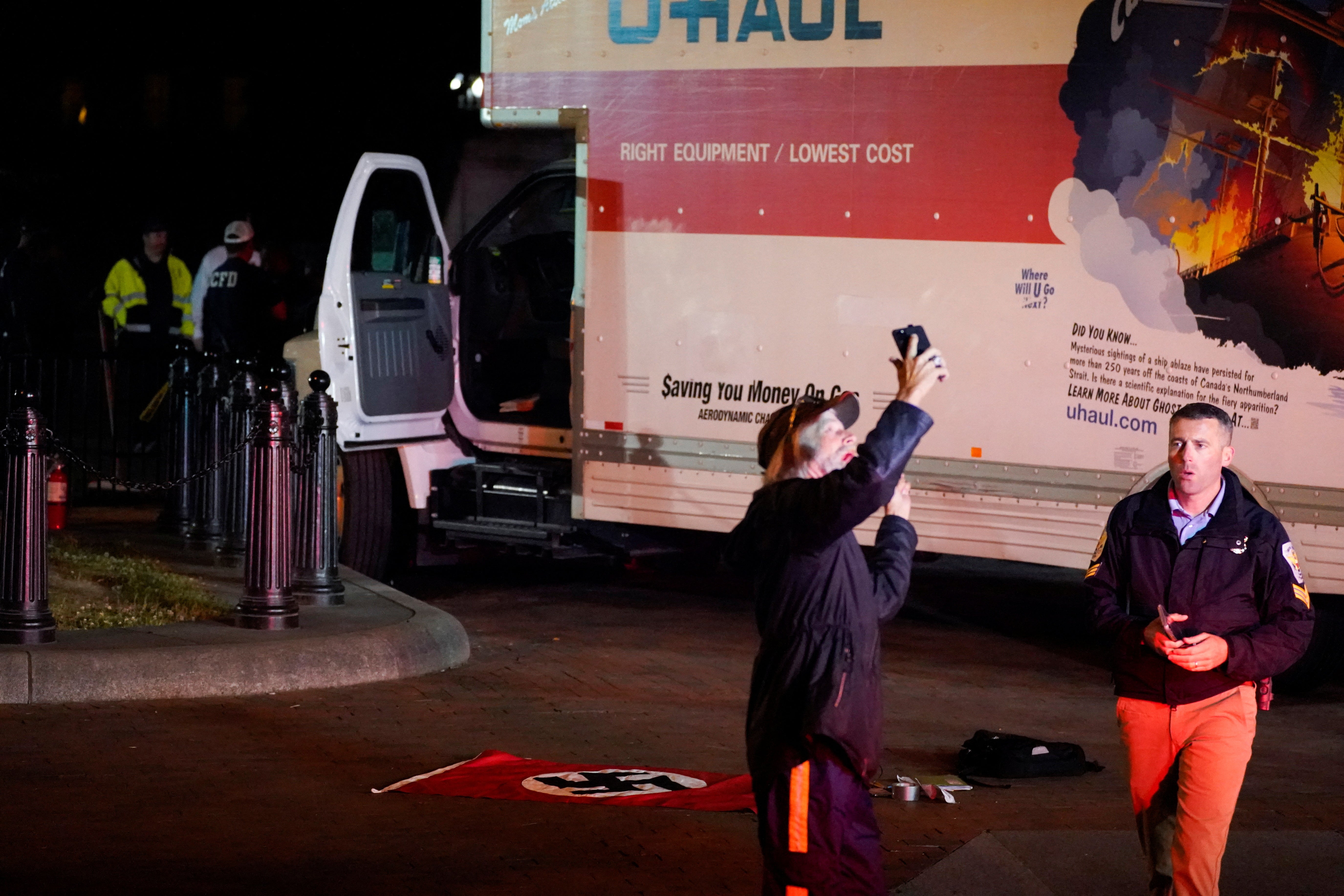 A bystander taking a selfie near a rented box truck is moved away by a US Secret Service agent as law enforcement agencies investigate the truck that crashed into security barriers at Lafayette Park across from the White House