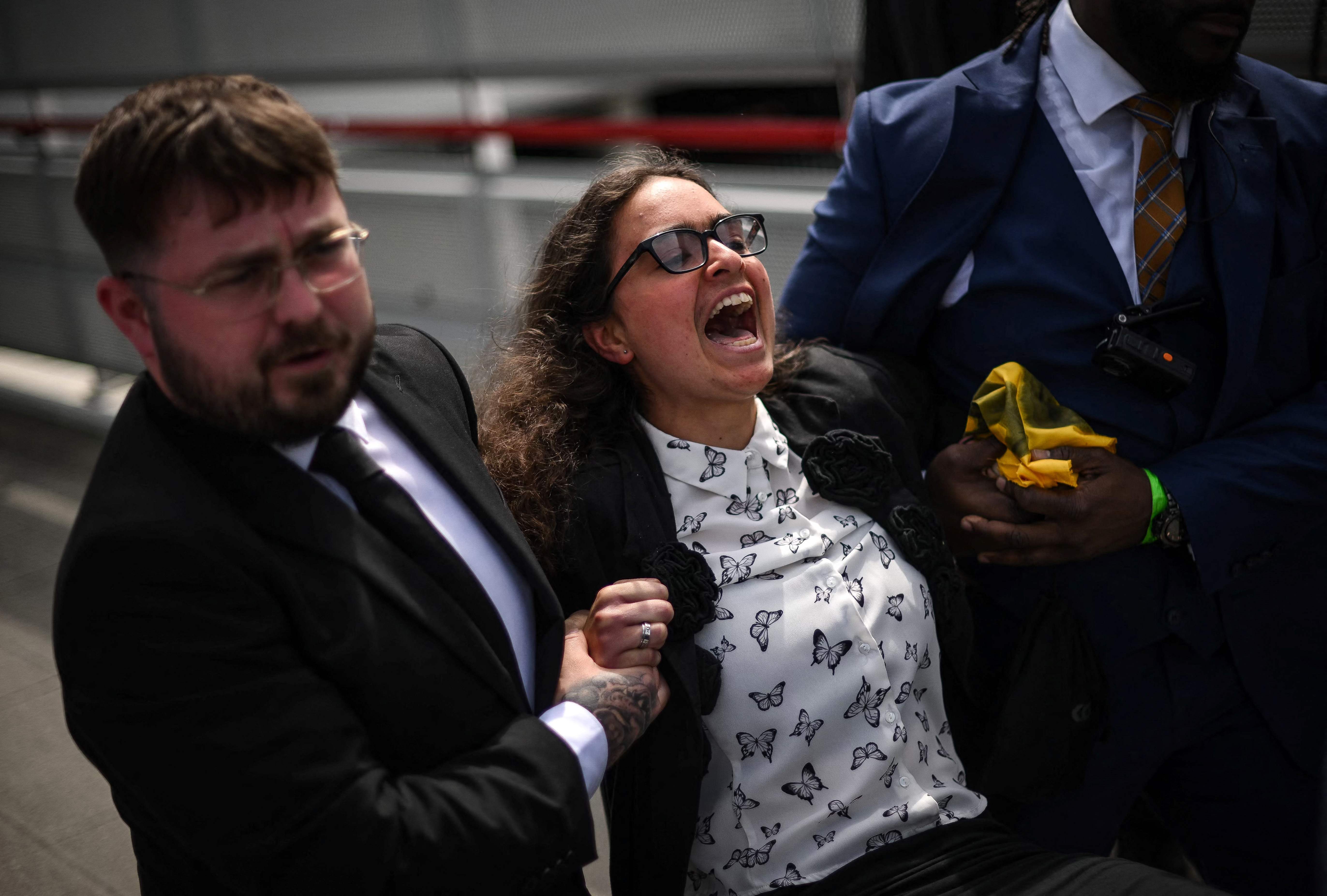 A member of Dutch activist group ‘Milieudefensie’ is dragged away from the Shell meeting