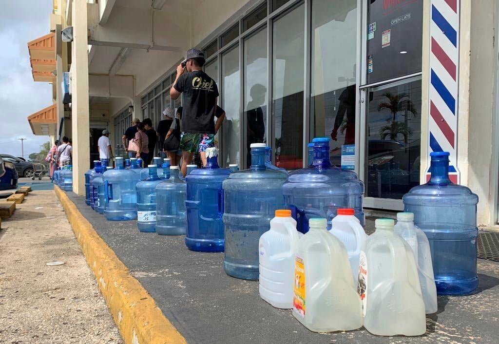 Numerous water containers line the sidewalk outside the Wellness Water & Ice store in Yigo, Guam