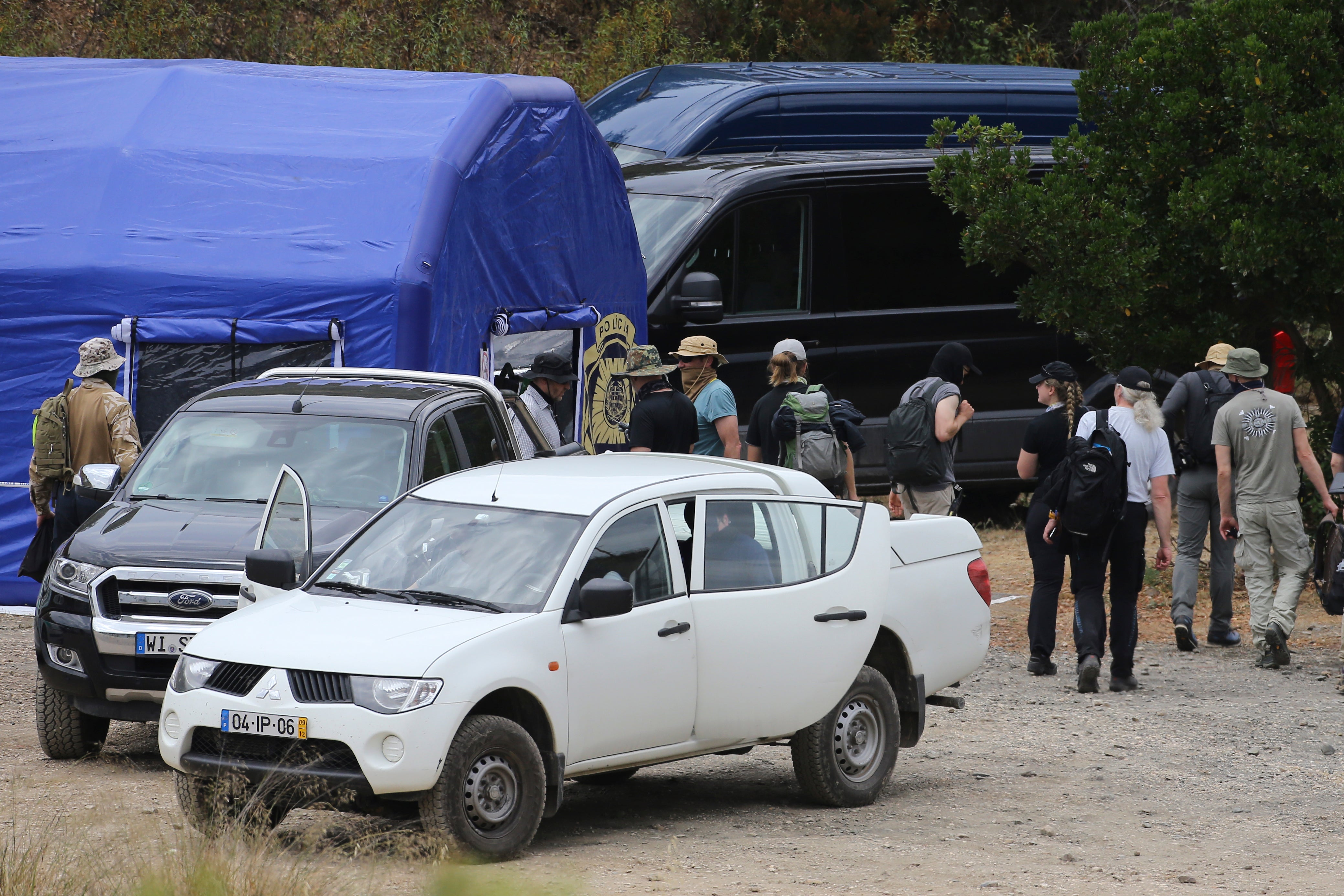 Search teams arrive back at one of the operation tents