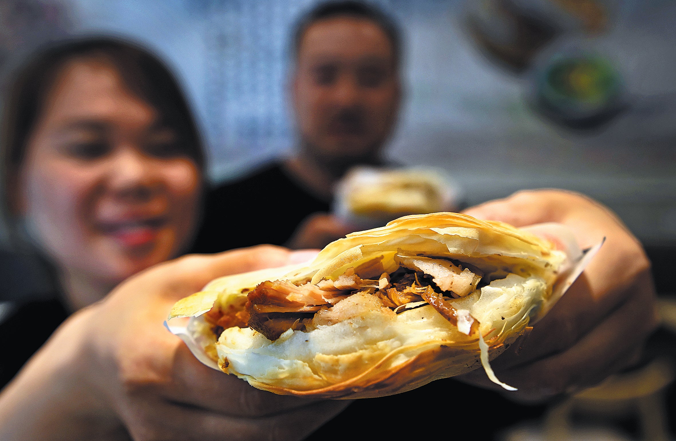 A customer displays roujiamo she bought from an eatery in Tongguan county, Shaanxi province