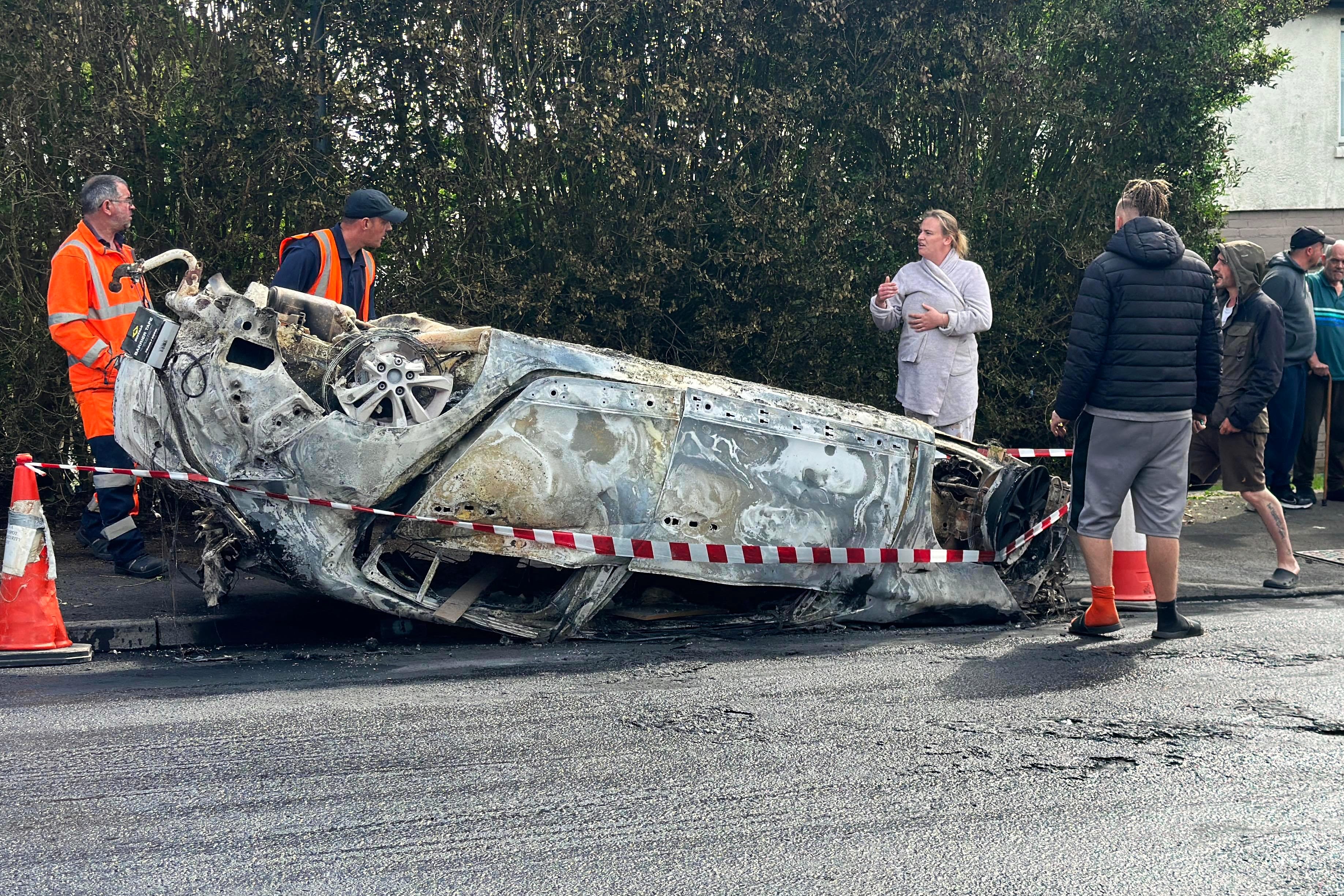 Council workers securing the area immediately around a car that was set alight in Ely