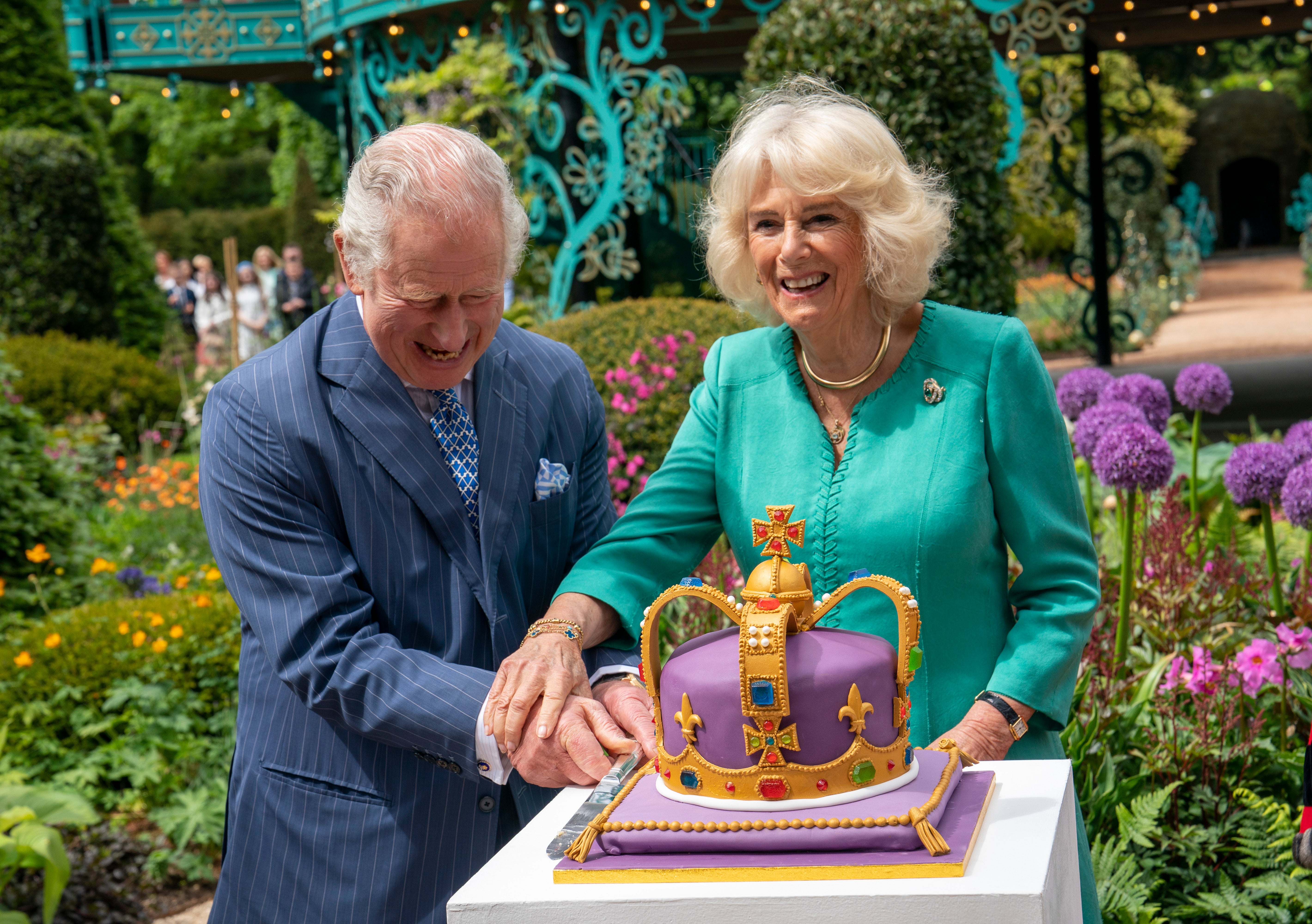 King Charles III and Queen Camilla cut a cake during a visit to open the new Coronation Garden on day one of their two-day visit to Northern Ireland on May 24, 2023