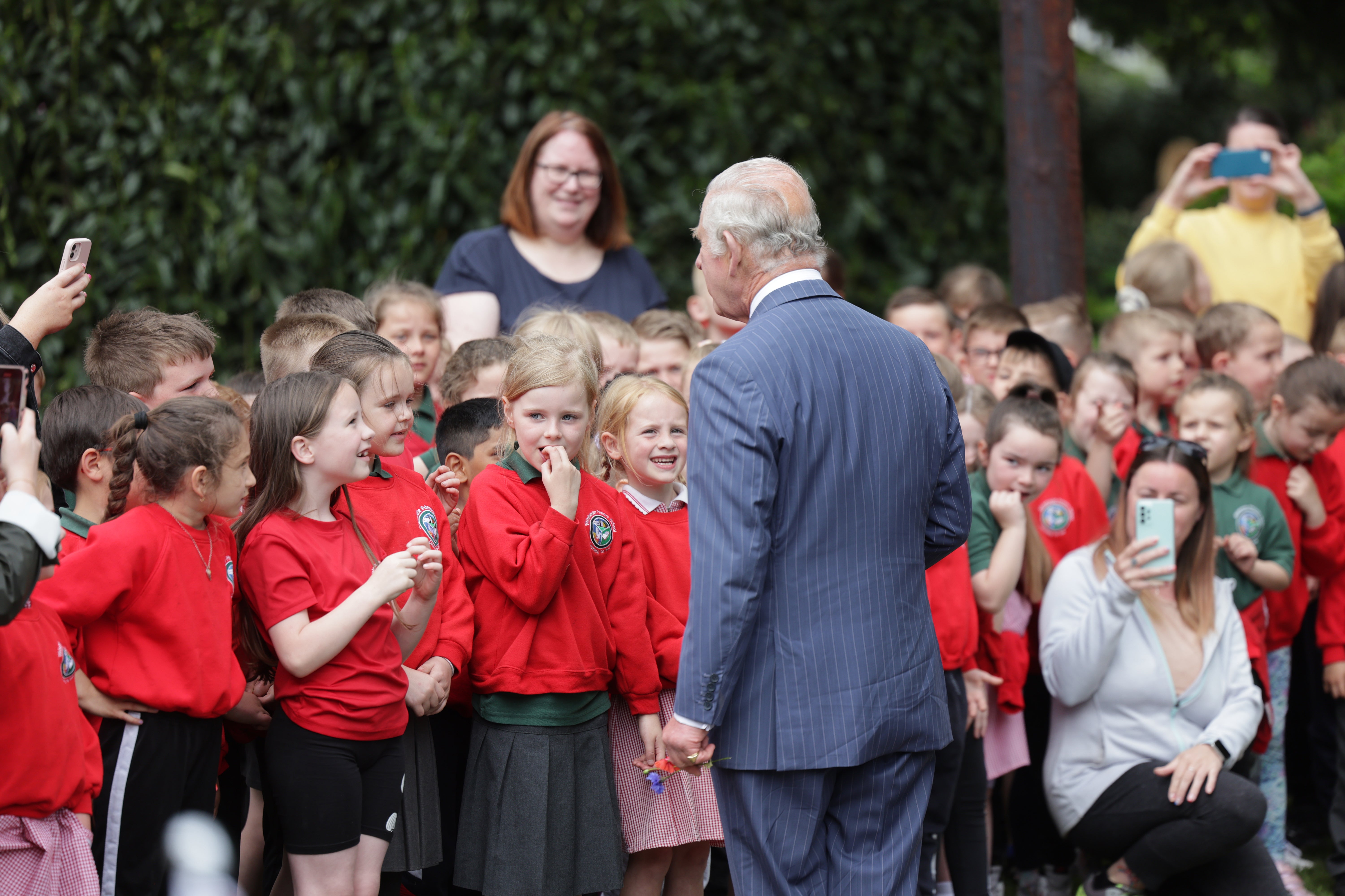 King Charles III greets school children after a visit to open the new Coronation Garden on day one of their two-day visit to Northern Ireland