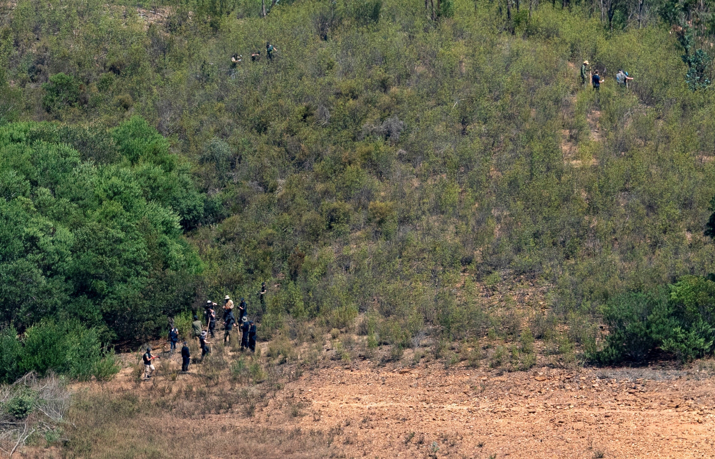 Police officers are seen at the site of a remote reservoir where search is underway for evidence related to the disappearance of Madeleine McCann