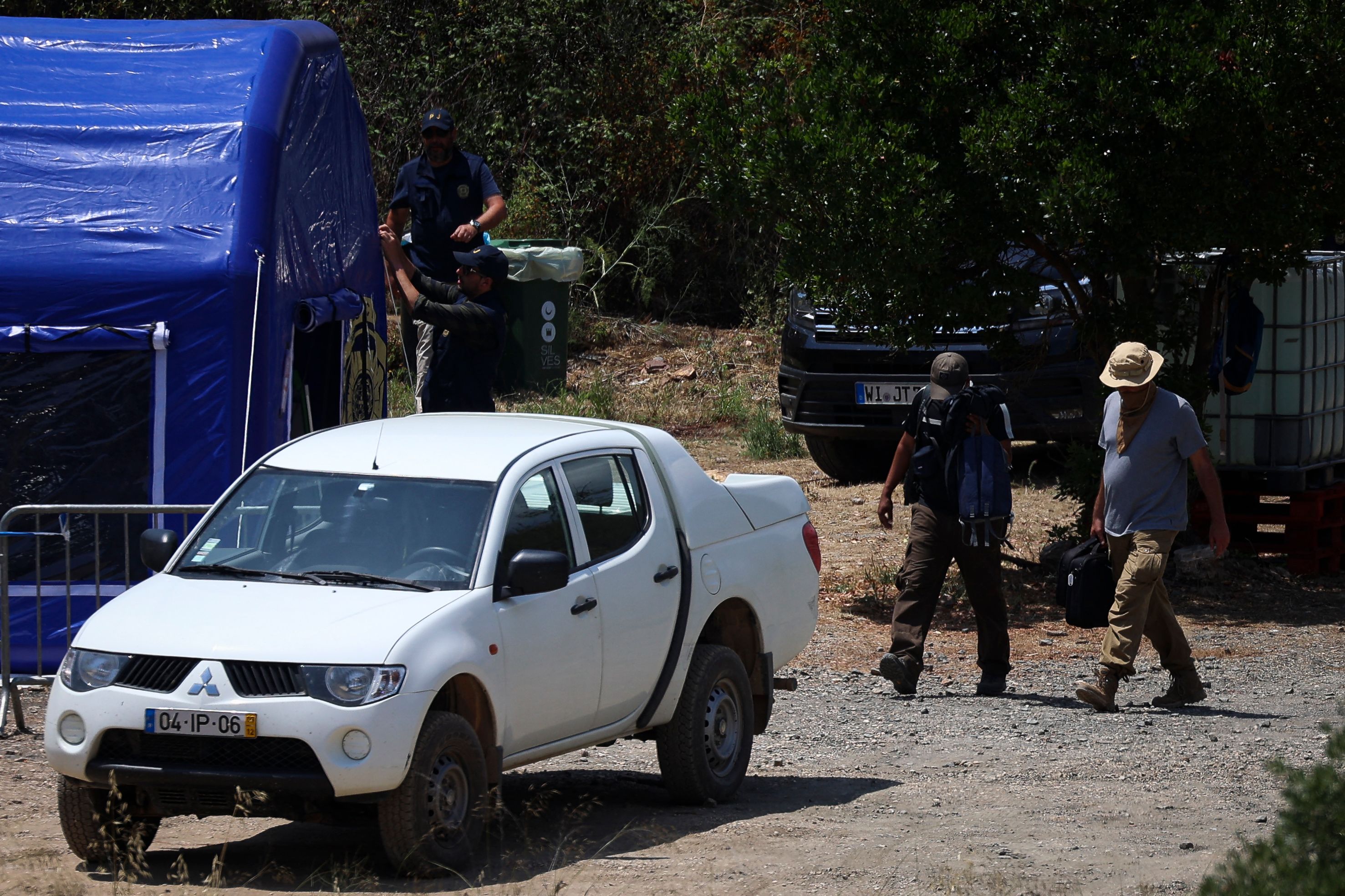 Judicial Police (PJ) criminal investigation unit members leave the base camp set near the Arade dam in Silves on May 25