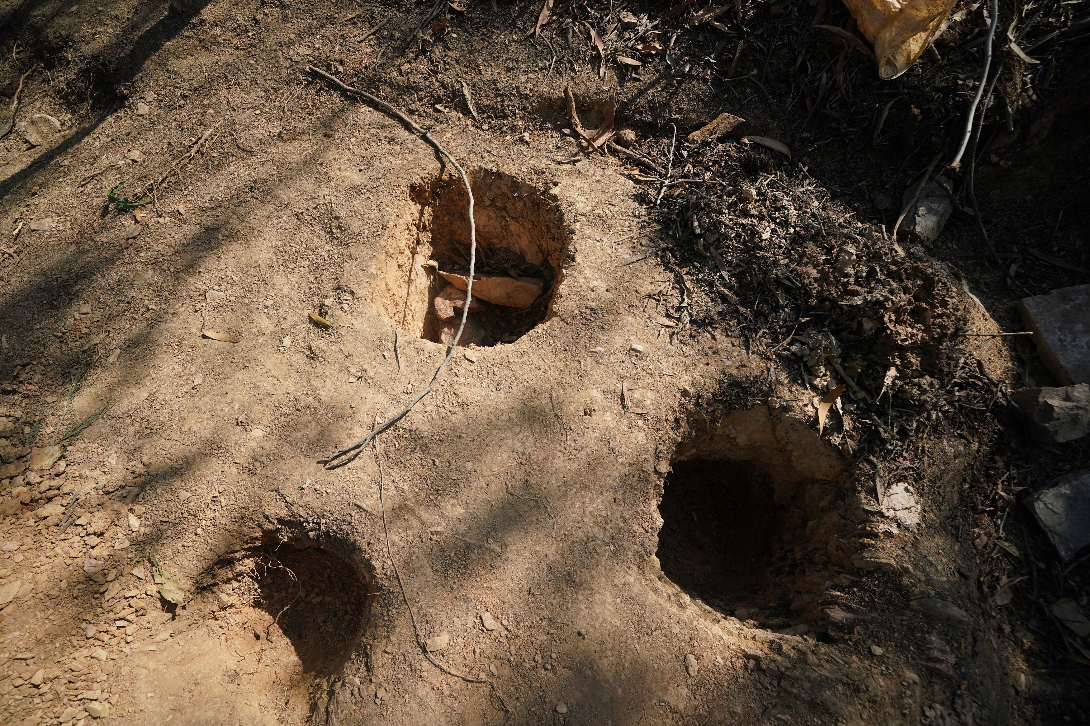 Holes dug apparently for soil samples in the area around Barragem do Arade reservoir, in the Algave, Portugal, after the area was reopened to media