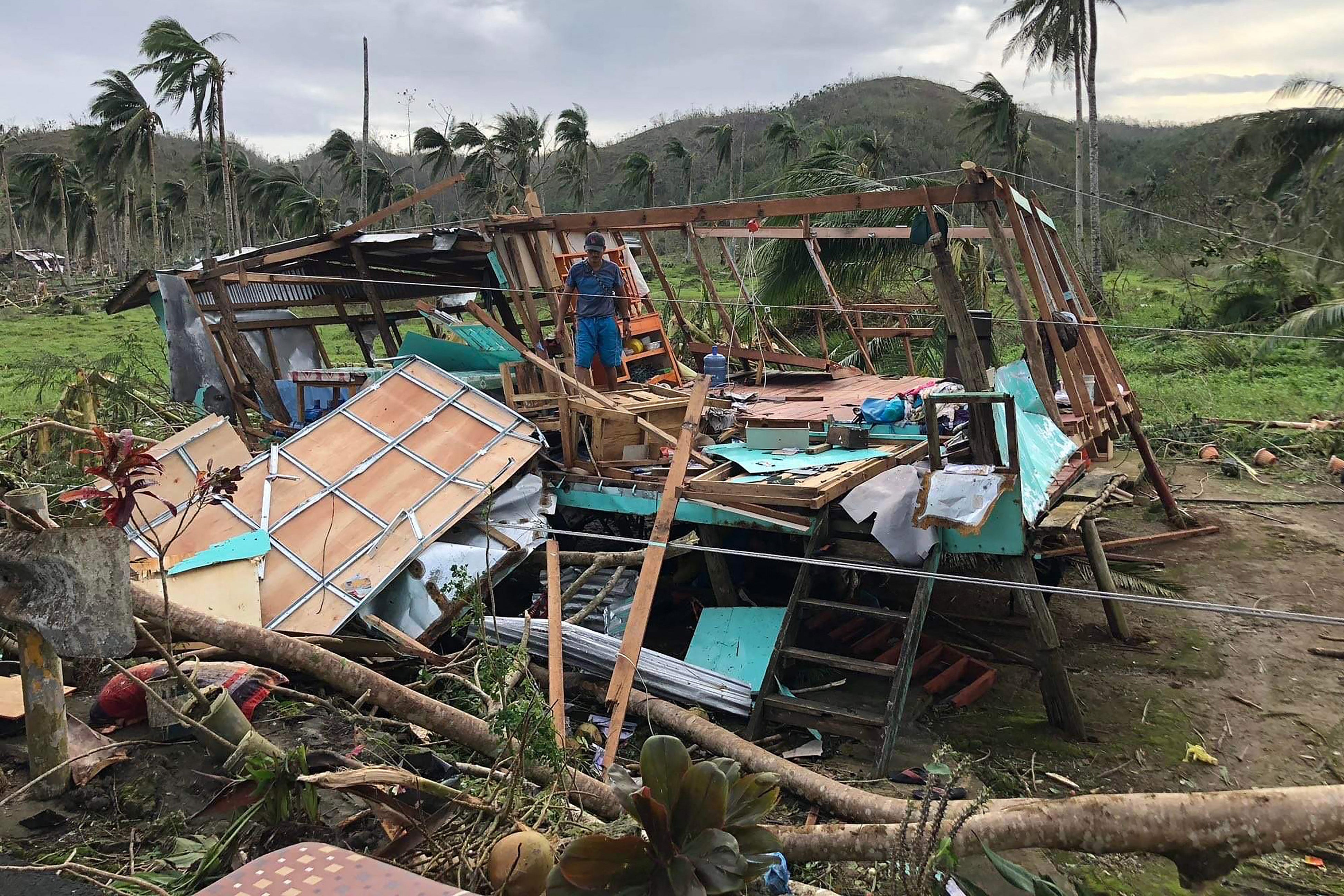 A resident stands on the remains of his wrecked house at a village in Dapa on Siargao island