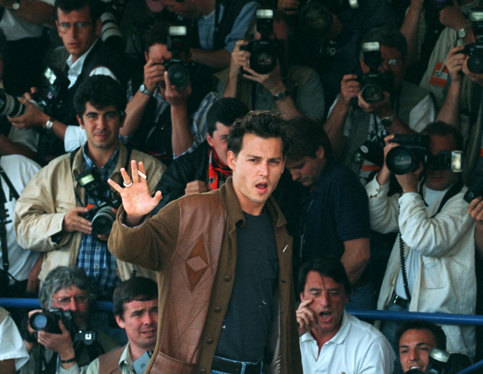 Johnny Depp waves to end a photo call for director Jim Jarmusch’s film ‘Dead Man’ at the 48th Cannes on 27 May 1995