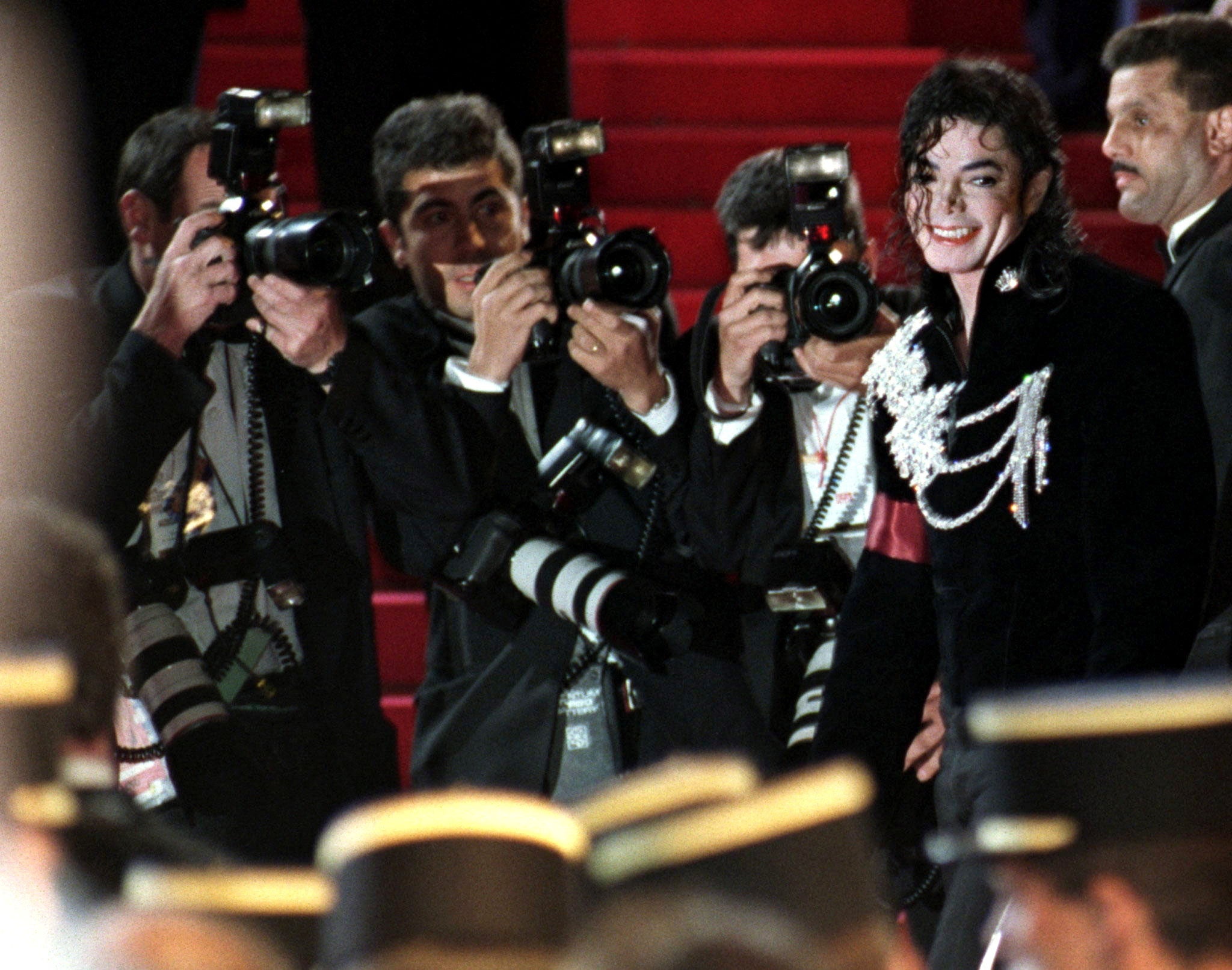 Photographers surround Michael Jackson as he arrives for the midnight screening of his movie short ‘Ghosts’ at the 50th Cannes on 8 May 1997