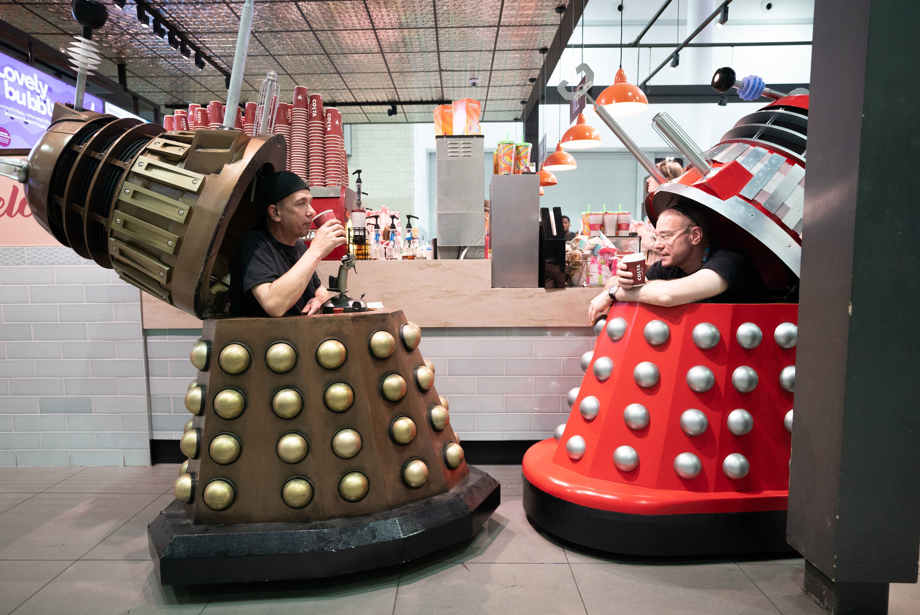 People drink coffee inside Daleks during MCM Comic Con at the ExCel London in east London