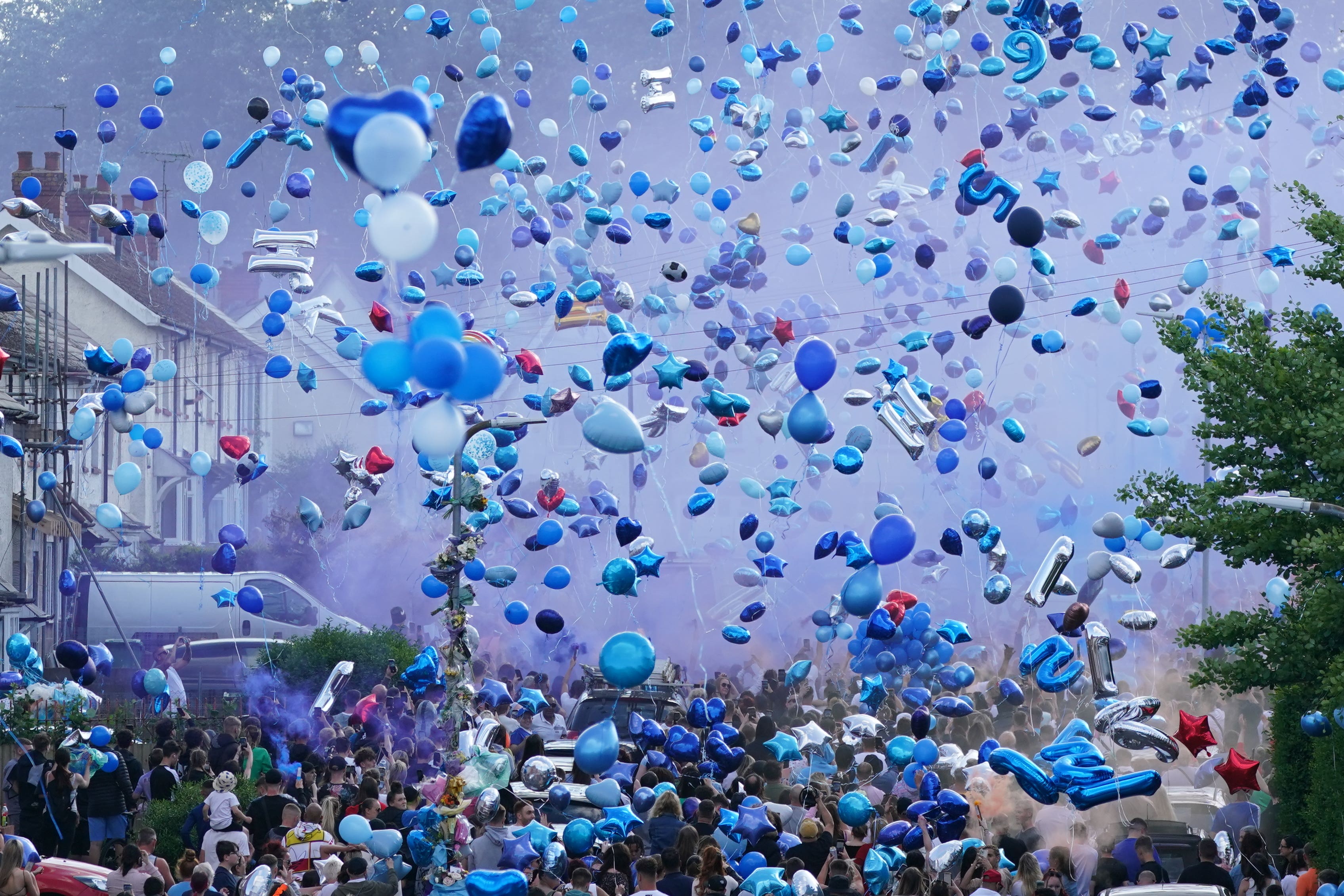 Mourners release balloons during a vigil for the victims of a road traffic collision on Snowden Road in Ely, Cardiff