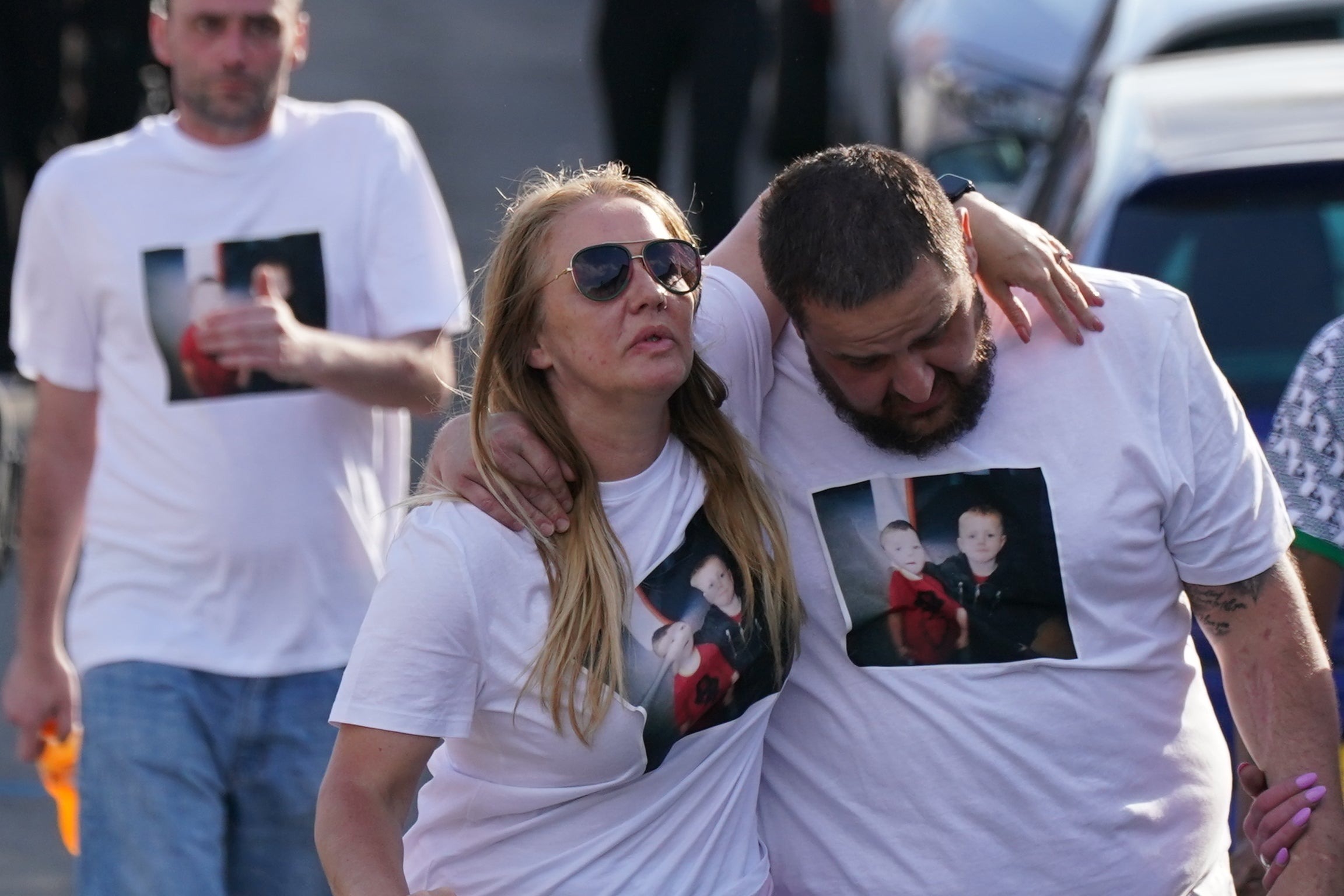 Many of those gathered at the vigil held blue balloons and wore white T-shirts adorned with pictures of the boys