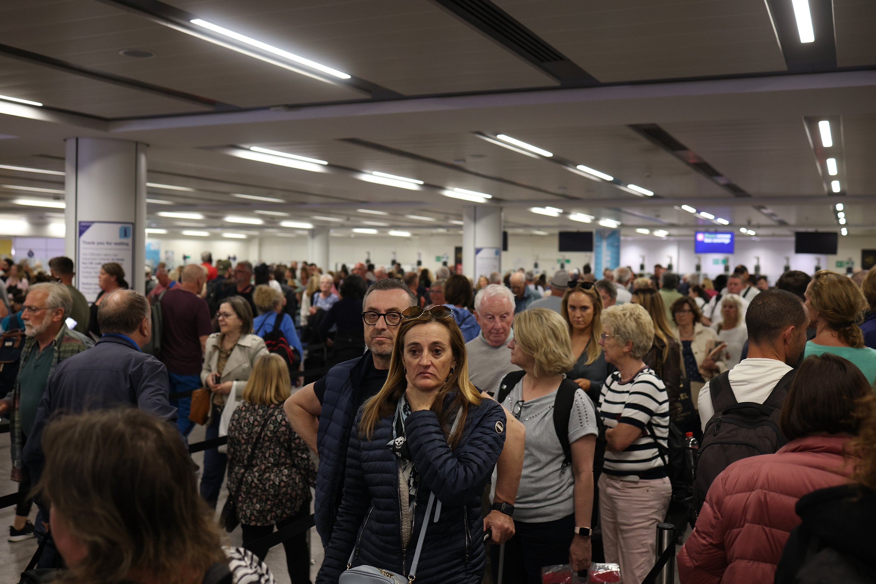 Passengers queue at Gatwick Airport as electronic passport gates fail across the UK