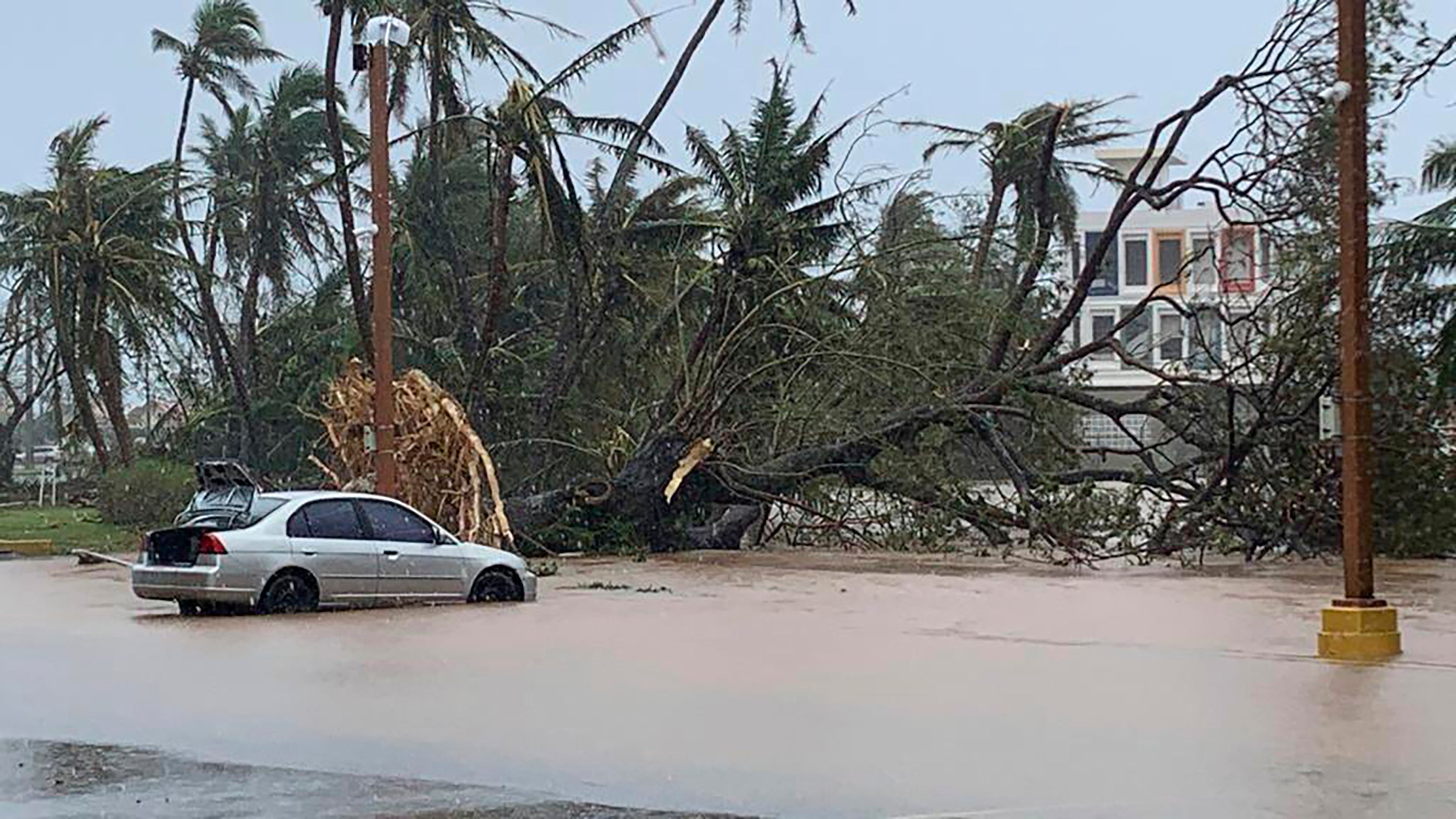 The waters of the Hagatna River overflows its banks and encroaches into the Bank of Guam parking lot in Hagatna, Guam, Thursday, May 25, 2023, in the aftermath of Typhoon Mawar