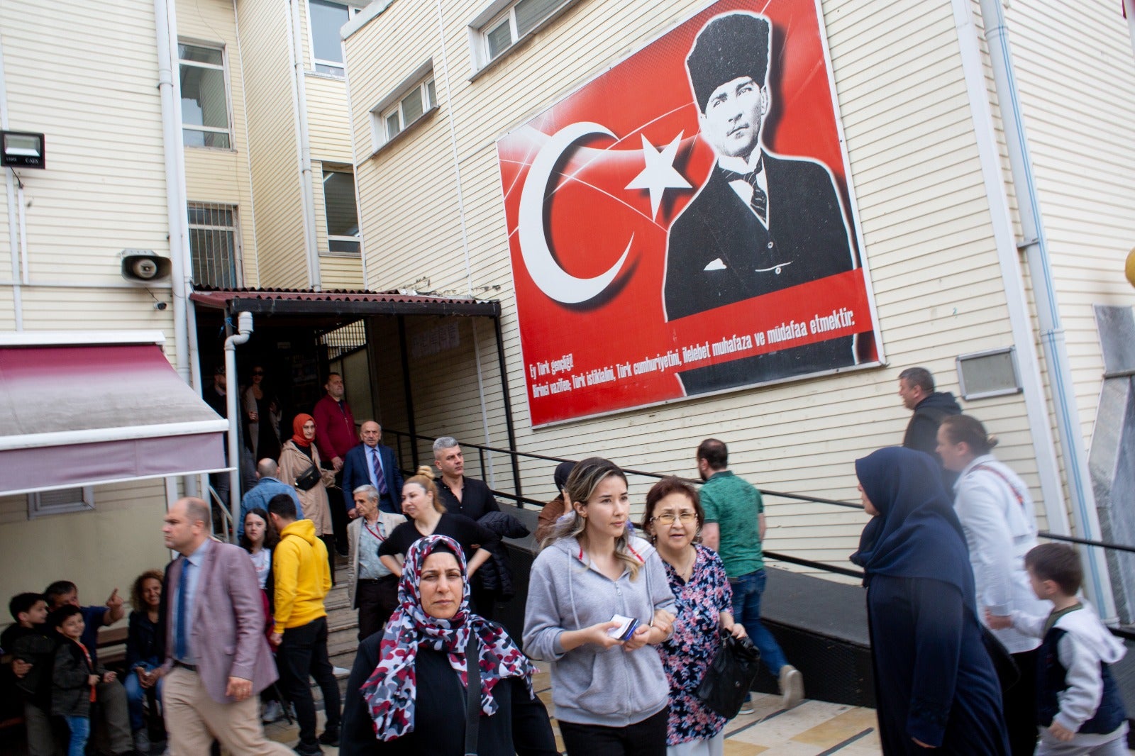 Voters emerge from a polling station in Istanbul beneath a portrait of Mustafa Kemal Ataturk, founder of modern Turkey,