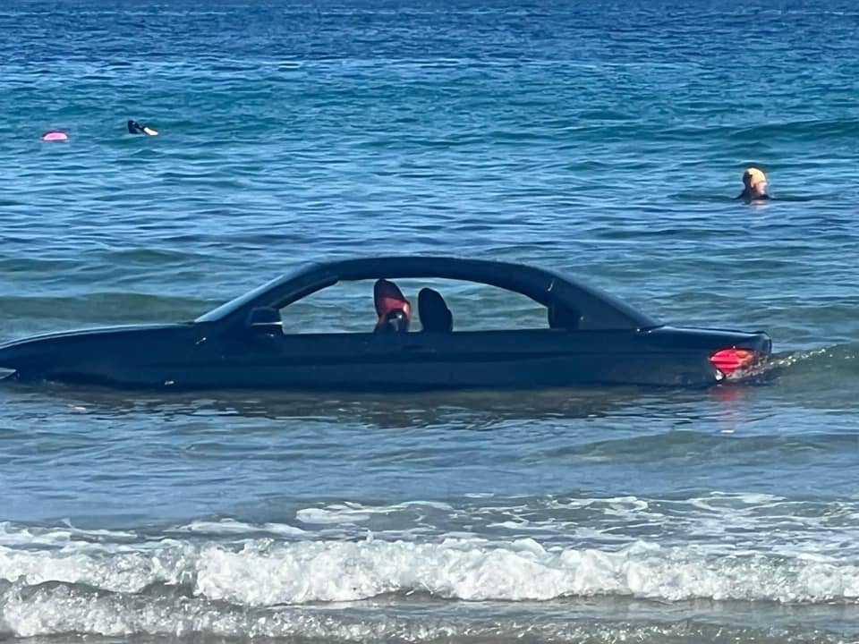 The car partially submerged in the water