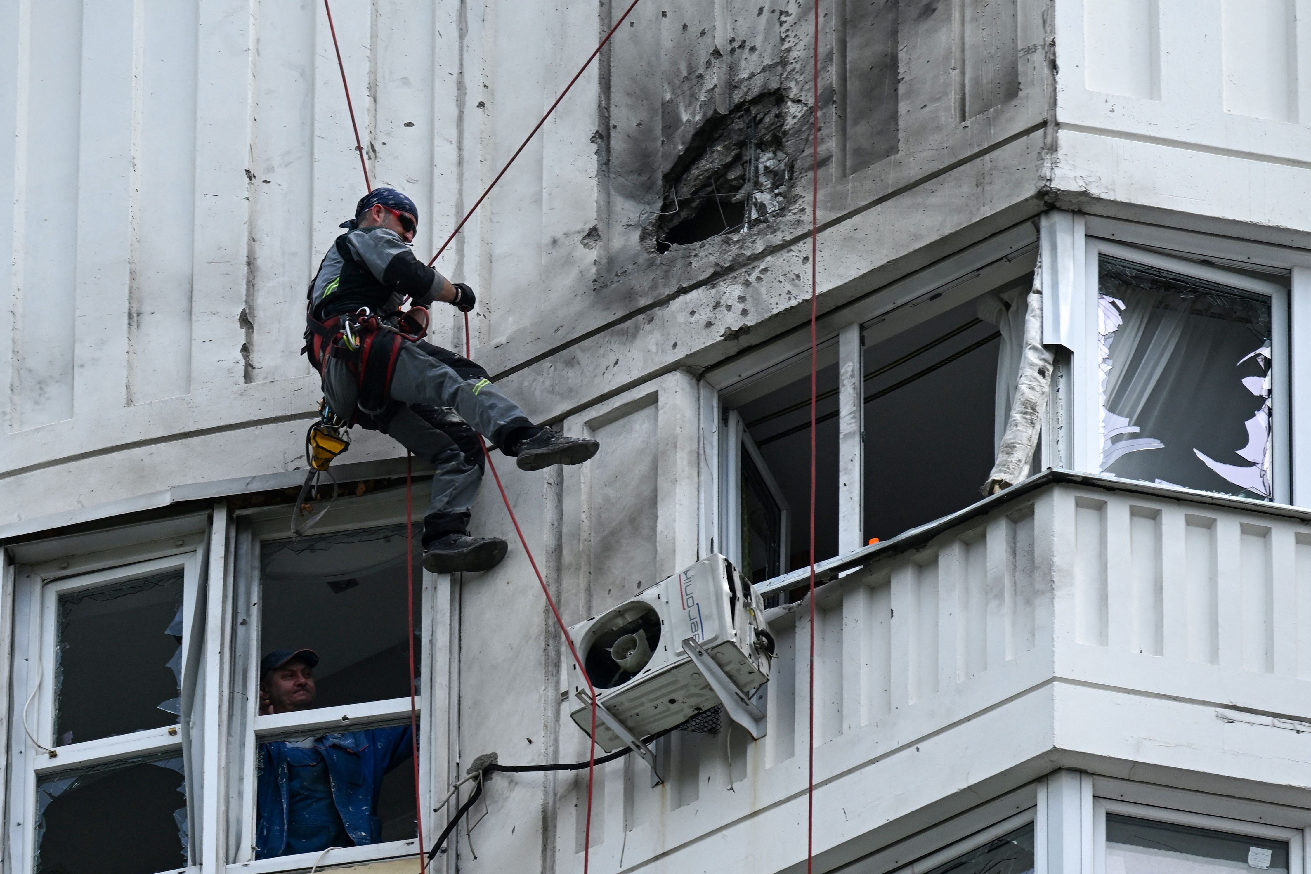 A specialist inspects an apartment building after a drone attack in Moscow