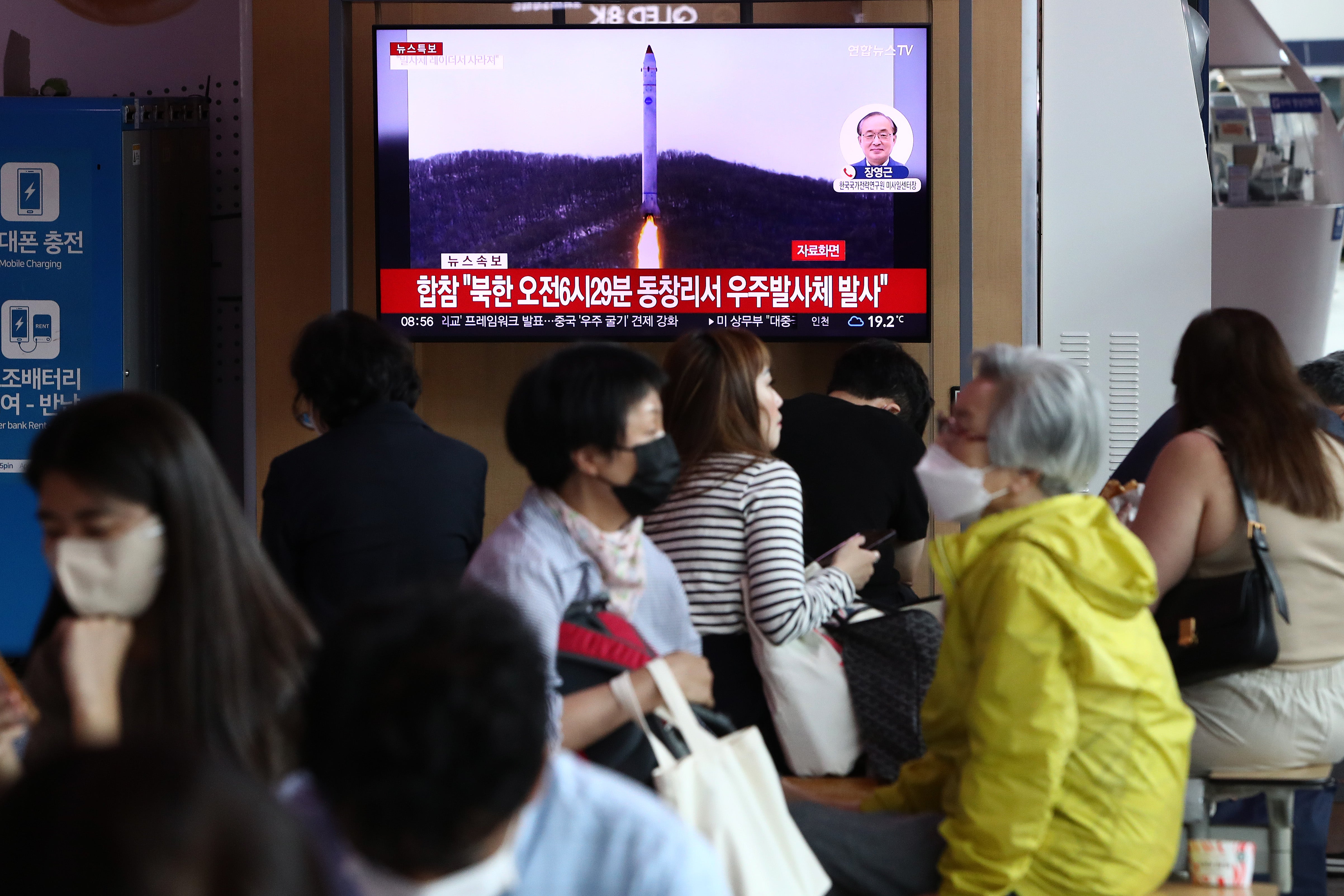 People watch a television broadcast showing a file image of a North Korean rocket launch at the Seoul Railway Station on 31 May