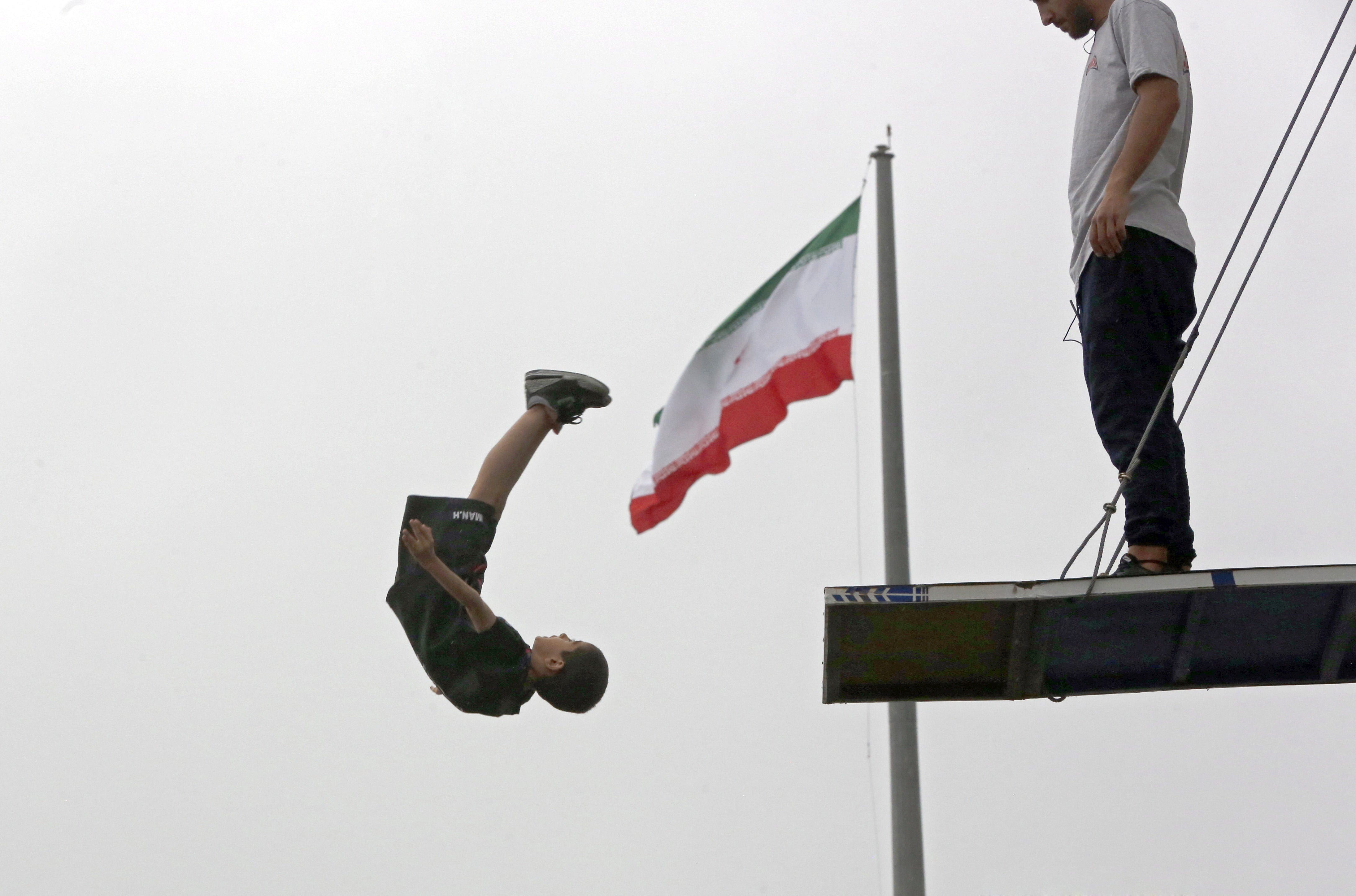 A boy jumps off a platform during a free jumping-diving competition at the Adrenaline Park, in Tehran, Iran