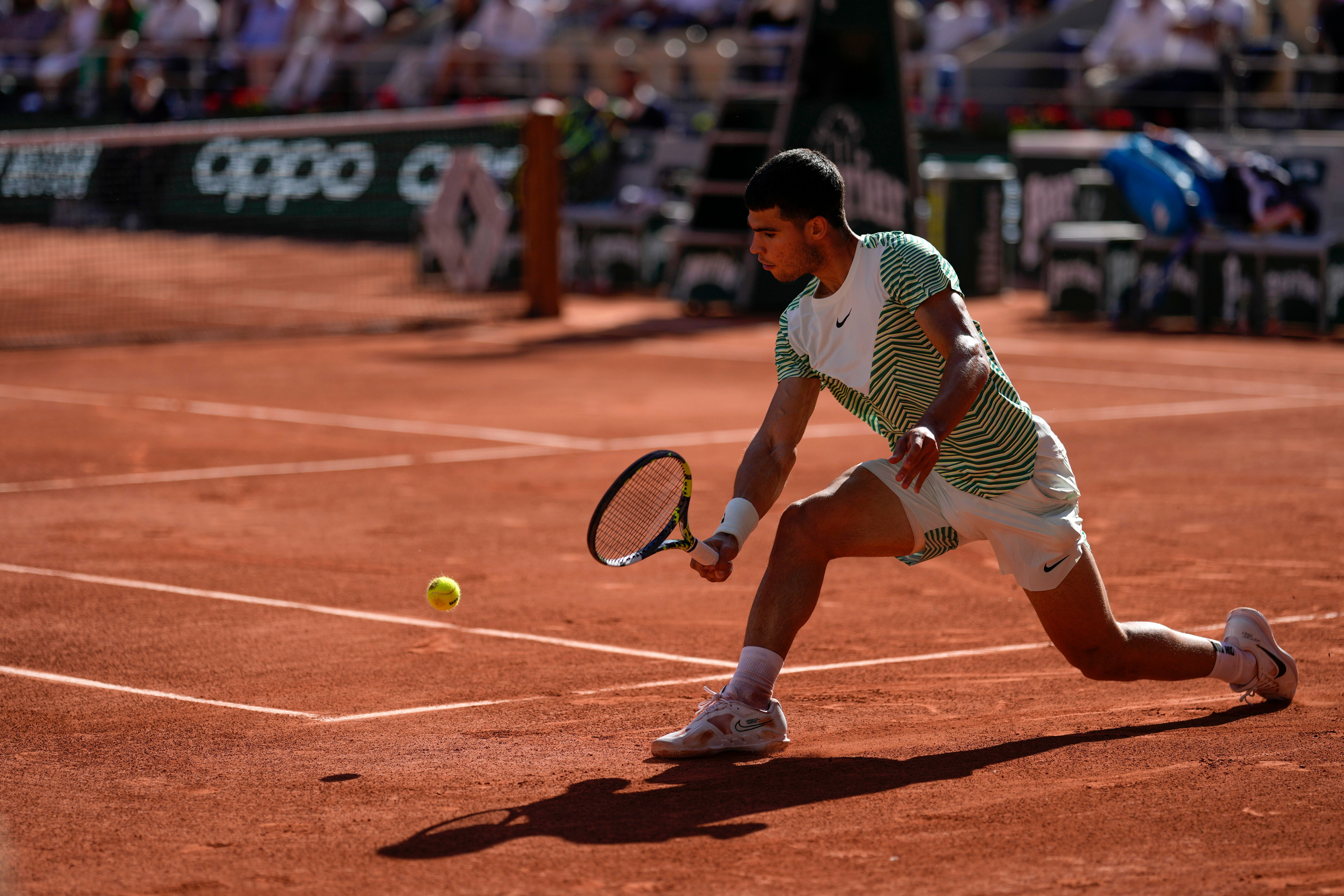 Carlos Alcaraz slides into a shot against Taro Daniel (Thibault Camus/AP)