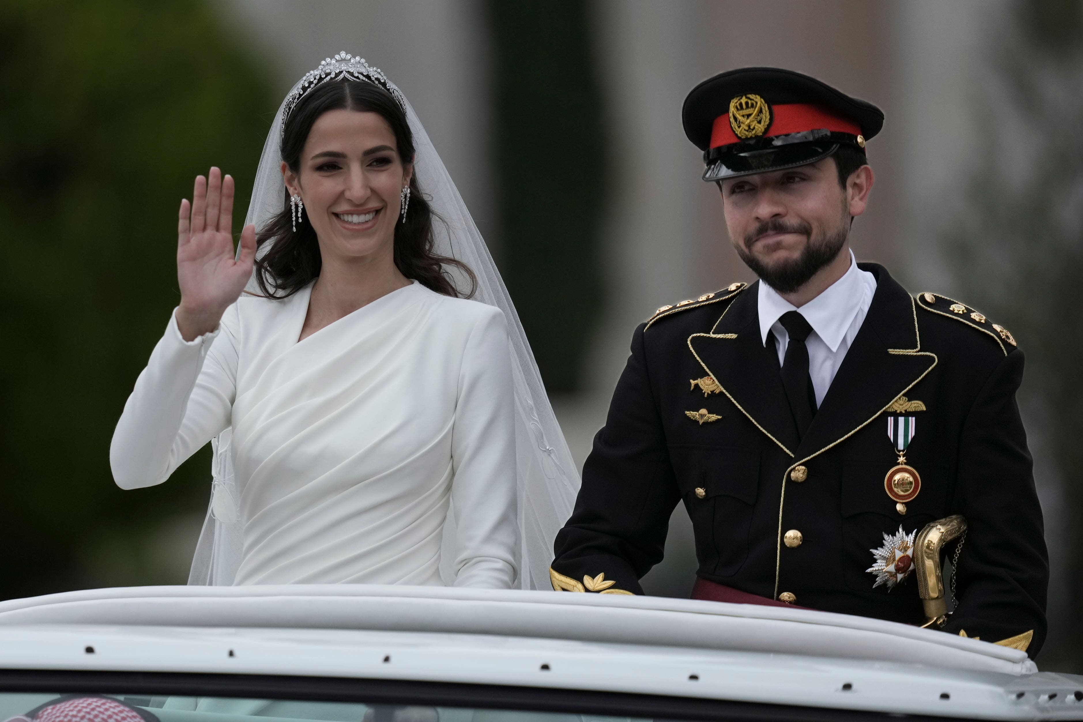 Jordan’s Crown Prince Hussein and Rajwa Alseif wave to well-wishers (Nasser Nasser/AP)