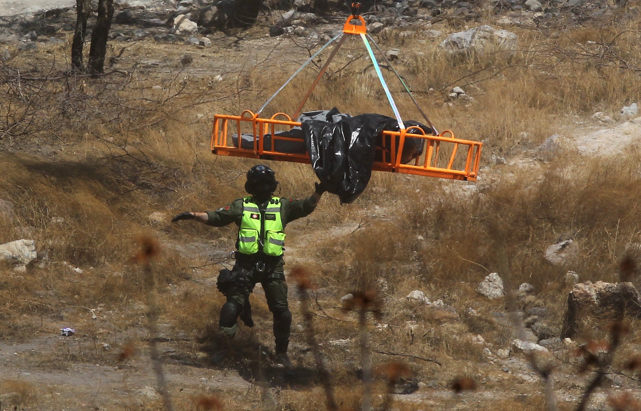 Forensic experts work with several bags of human remains extracted from the bottom of a ravine by a helicopter, which were abandoned at the Mirador Escondido community in Zapopan, Jalisco state, Mexico on May 31, 2023