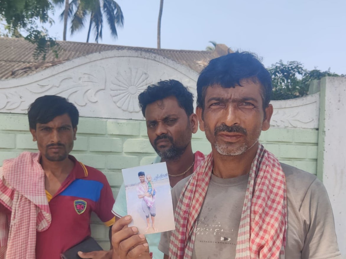 Tapan Kumar Jana holds the picture of his missing neighbour Manash Maitey