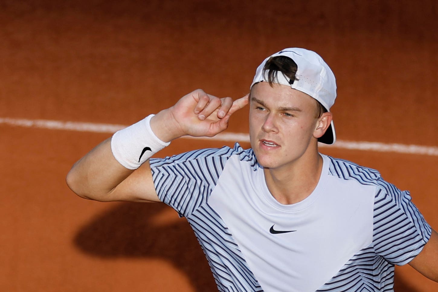 Holger Rune puts his finger to his ear after beating Argentina’s Francisco Cerundolo (Jean-Francois Badias/AP)