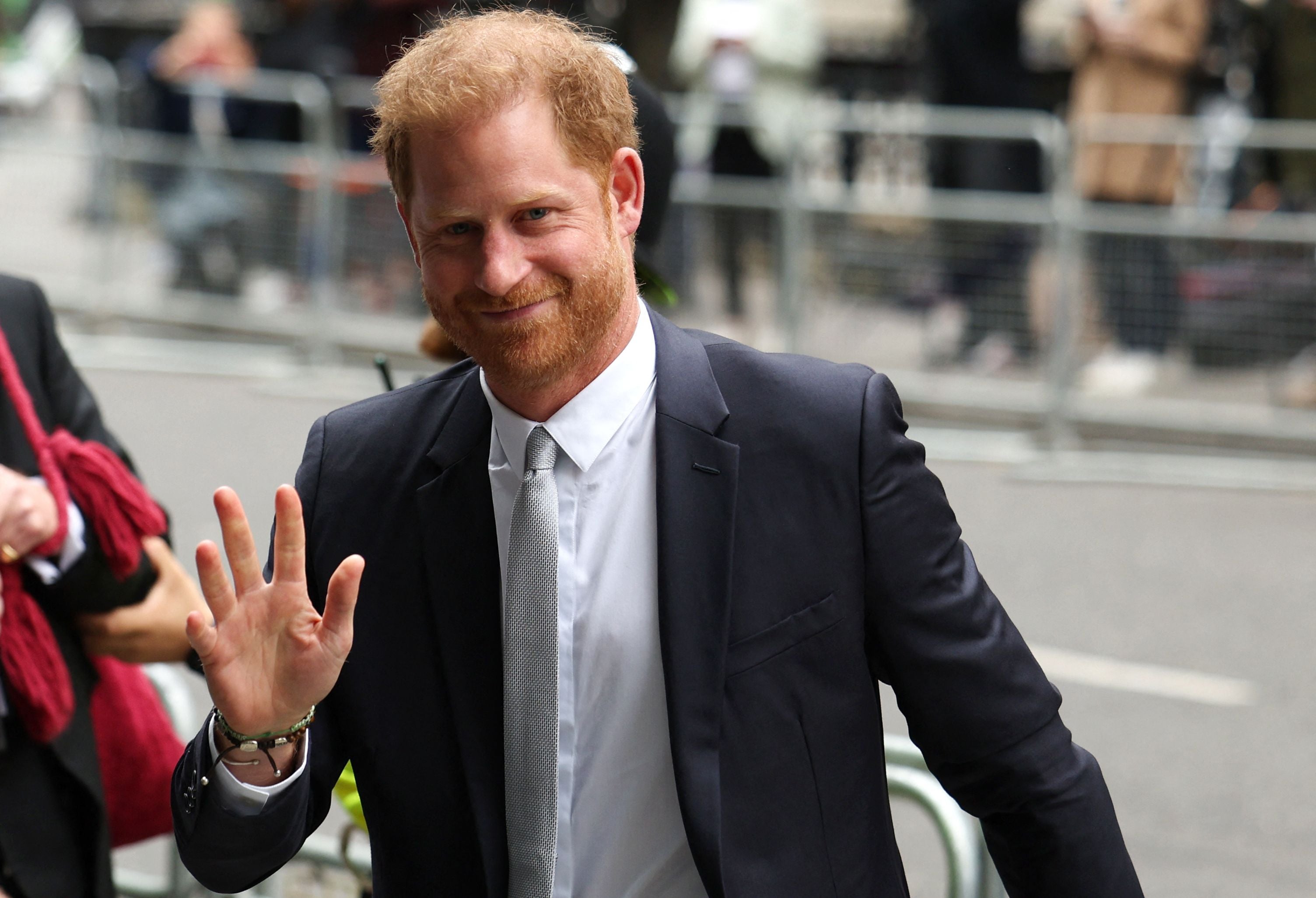 Harry waves as he enters the court