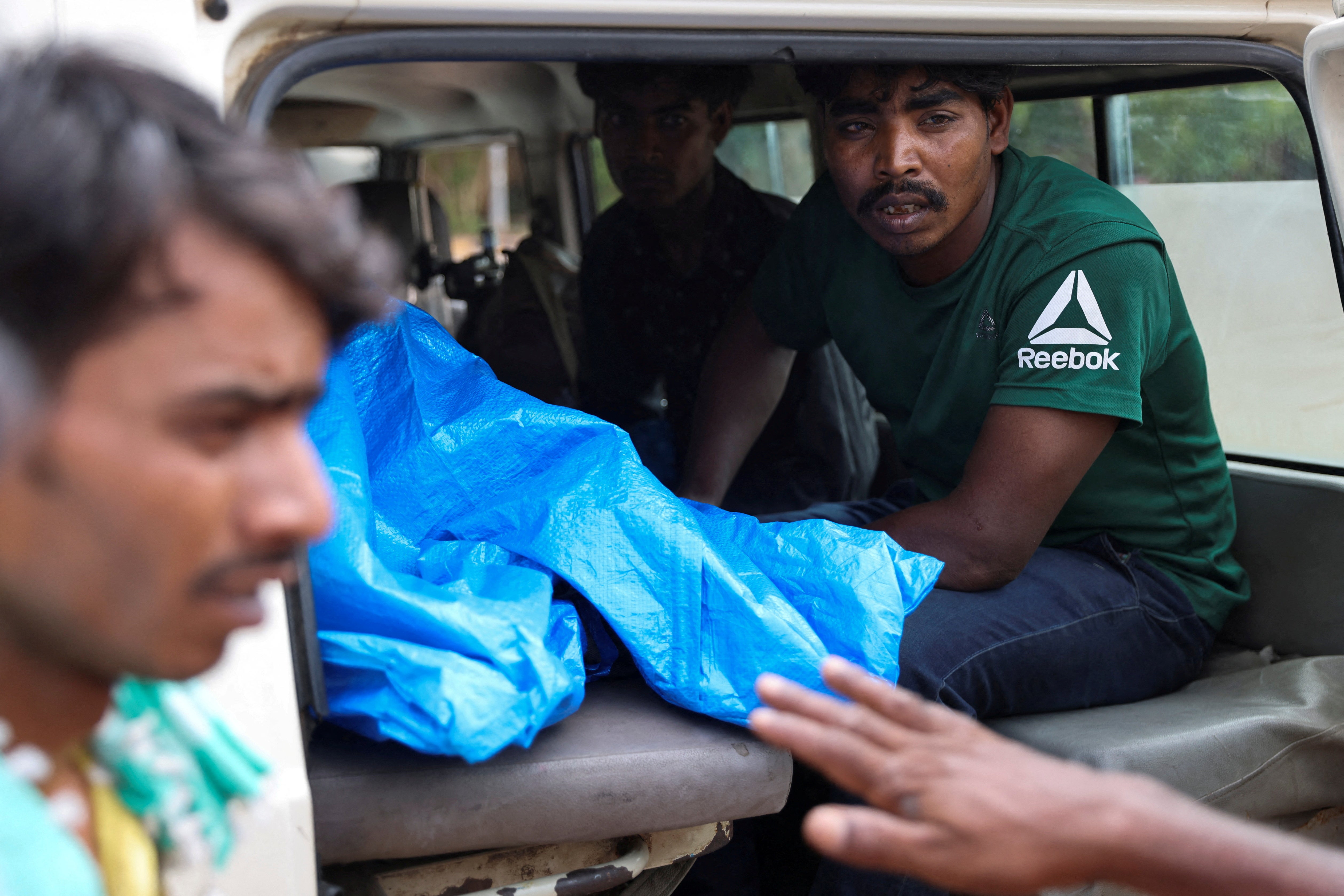 Mohammad Imam Ul Haq’s relatives bid farewell to other family members before an ambulance leaves with a makeshift coffin carrying his nephew