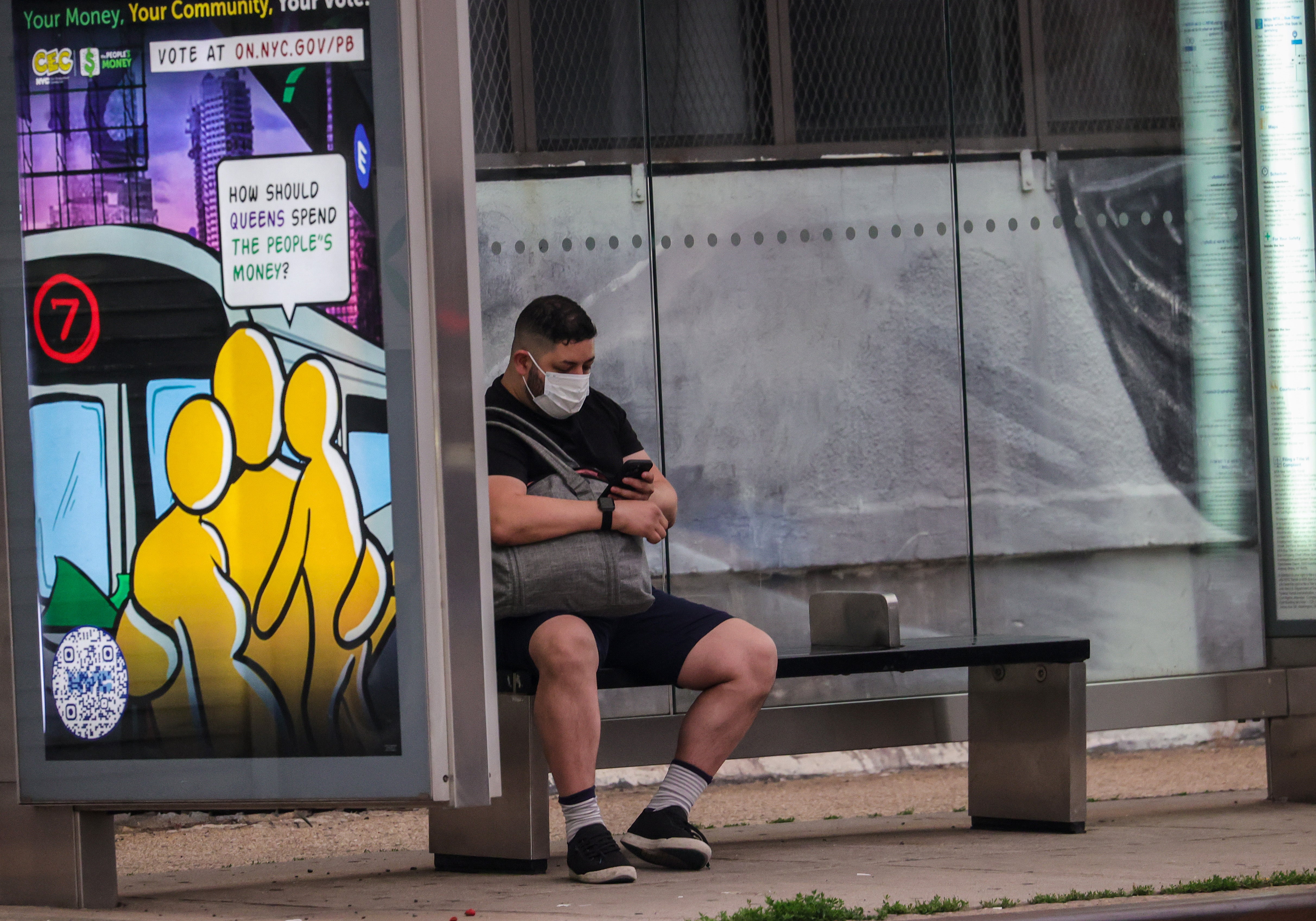 A man sits in the bus stop with a mask on his face in New York City, United States on 6 June 2023