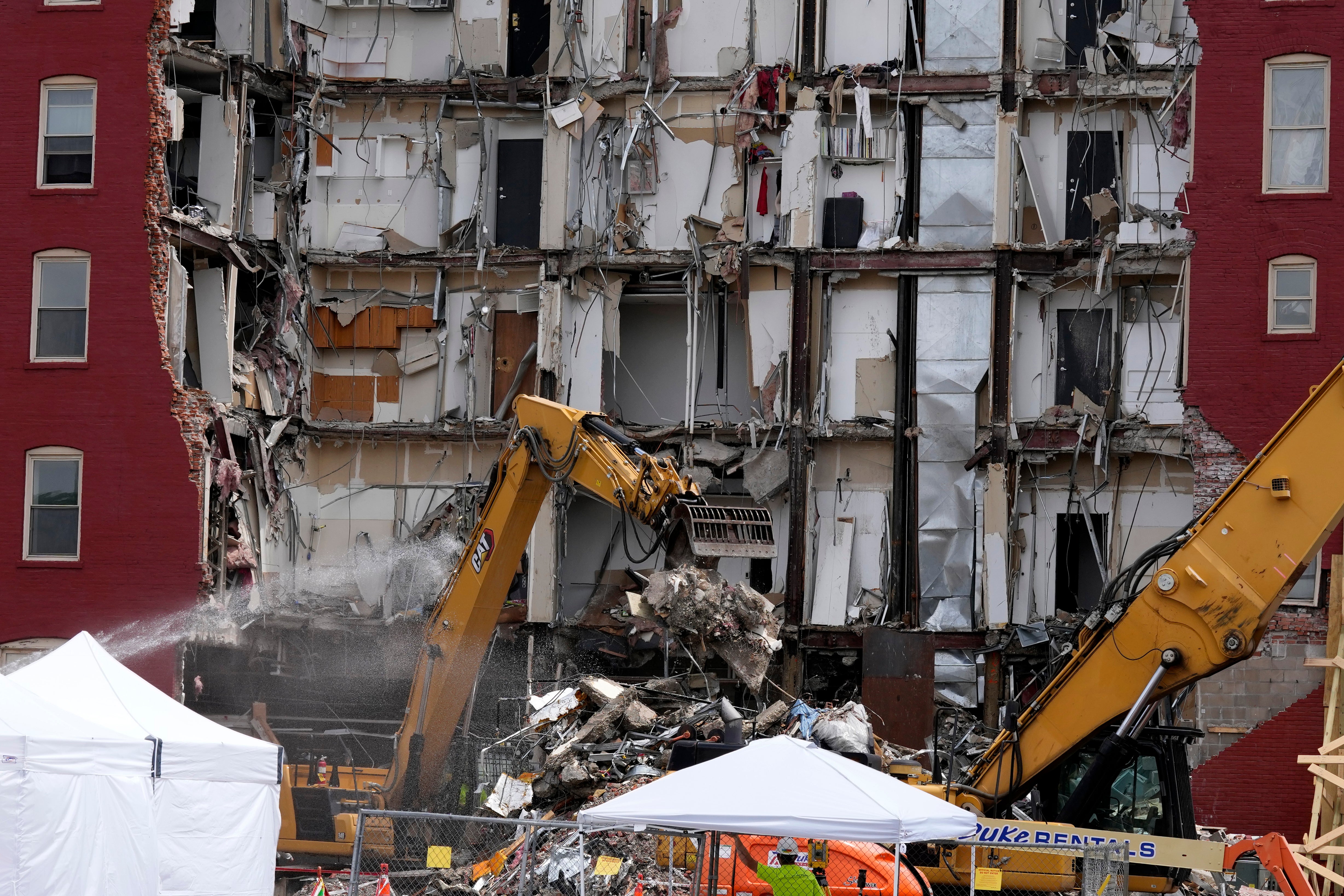 Workers move debris at the site of a building collapse, Monday, June 5, 2023, in Davenport, Iowa