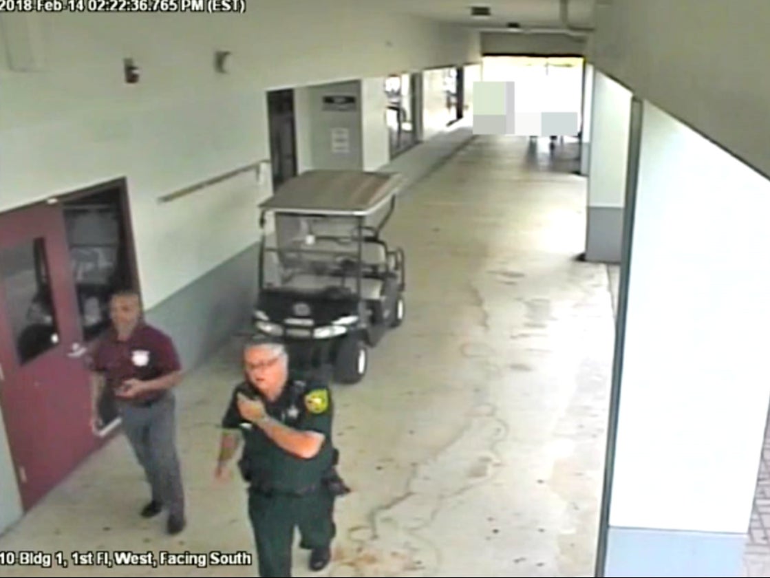 Former Broward County deputy Scot Peterson walking with an unarmed security guard outside Marjorie Stoneman Douglas High School during the Parkland mass shooting