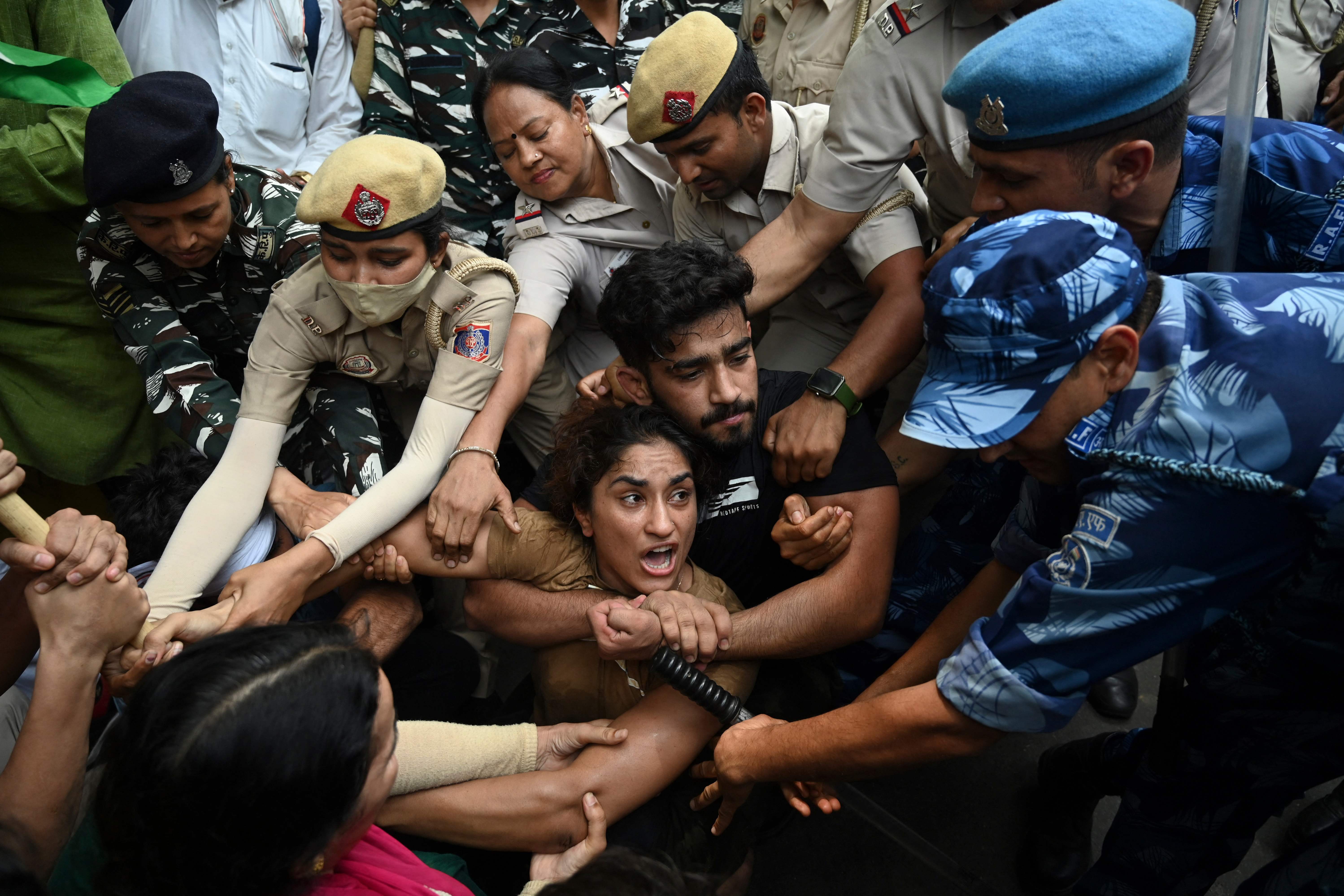 Indian wrestlers Vinesh Phogat (C) with others are detained by the police while attempting to march to India’s new parliament on 28 May