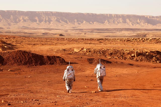 <p>Astronauts walk in spacesuits during a training mission for planet Mars at a site that simulates an off-site station</p>