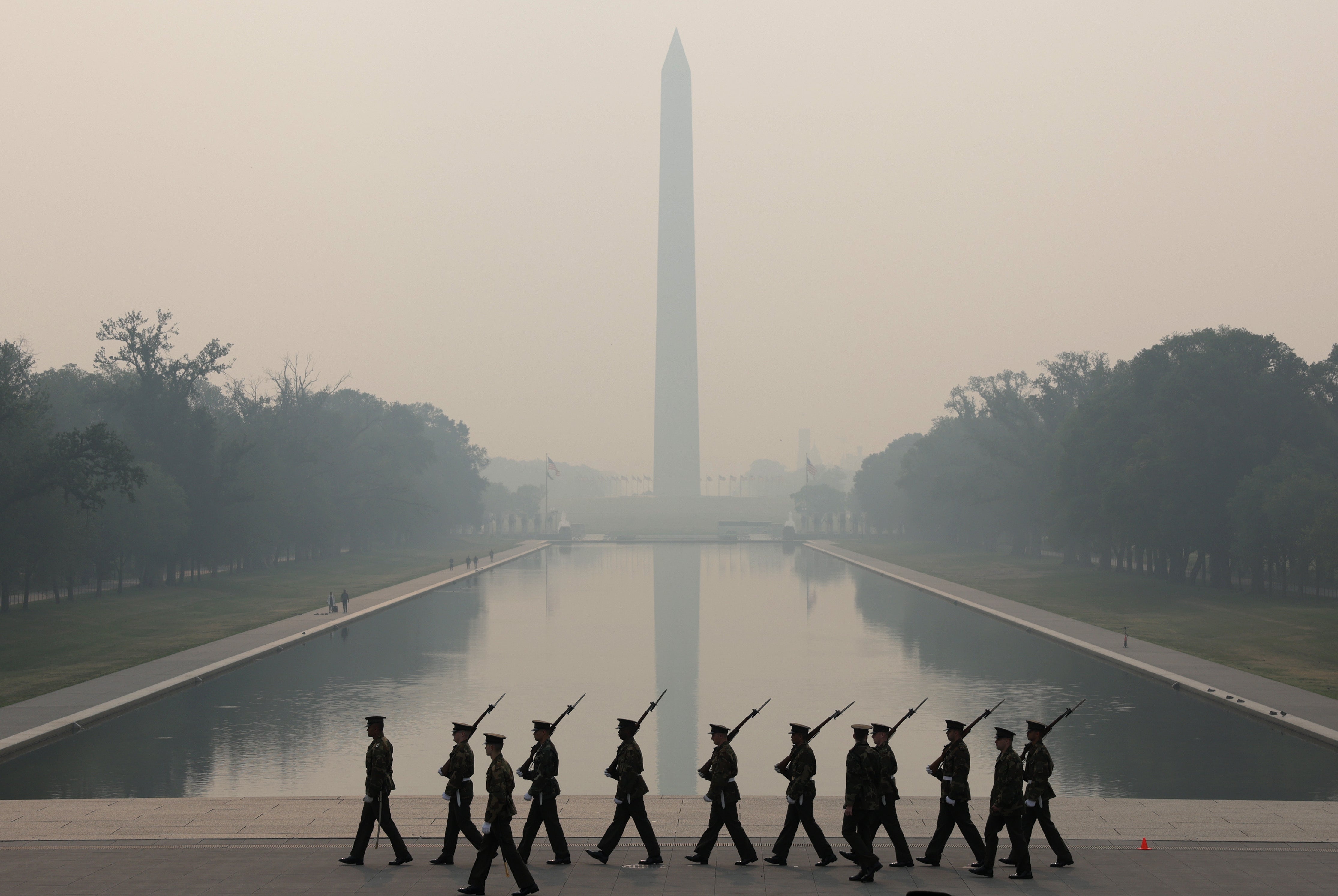 Members of the US Marine Corps rehearse in hazy smoke for the Sunset Parade at the Lincoln Memorial on June 8, 2023 in Washington, DC