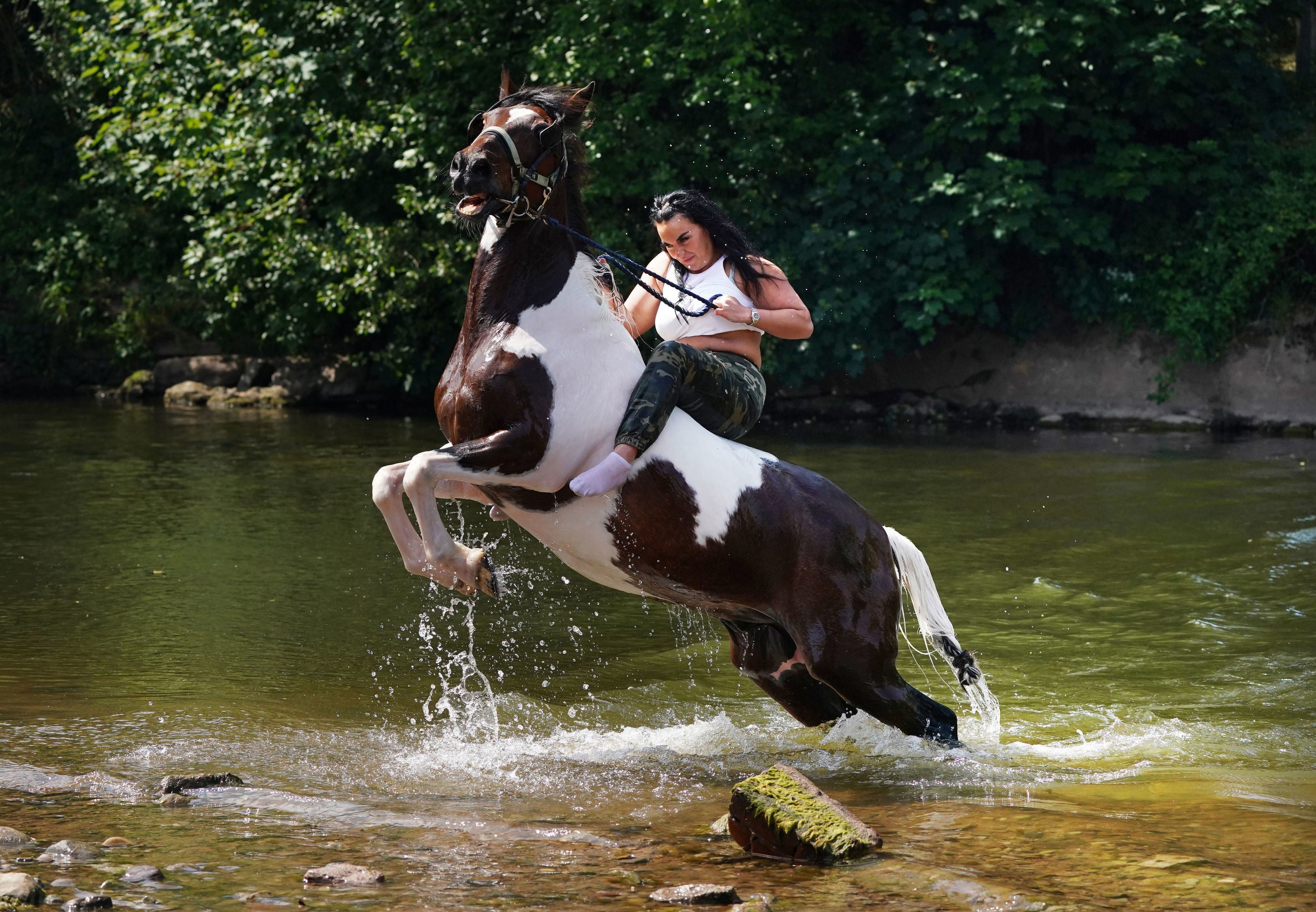 A women rides her horse through the river during the Appleby Horse Fair