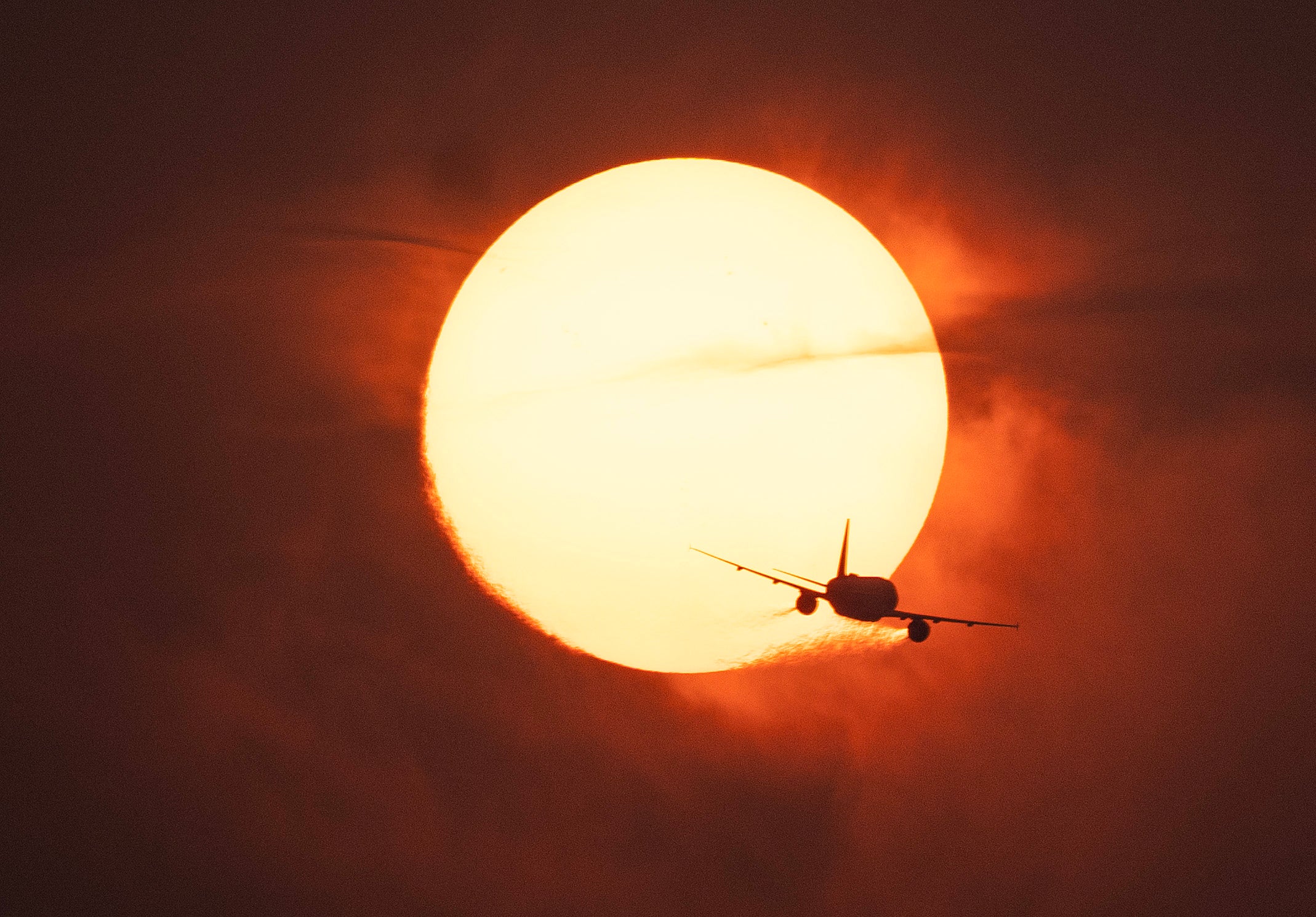 A plane passes in front of the sun on a hazy evening as smoke from wildfires in Canada cause hazy conditions in Washington, DC, on June 7, 2023