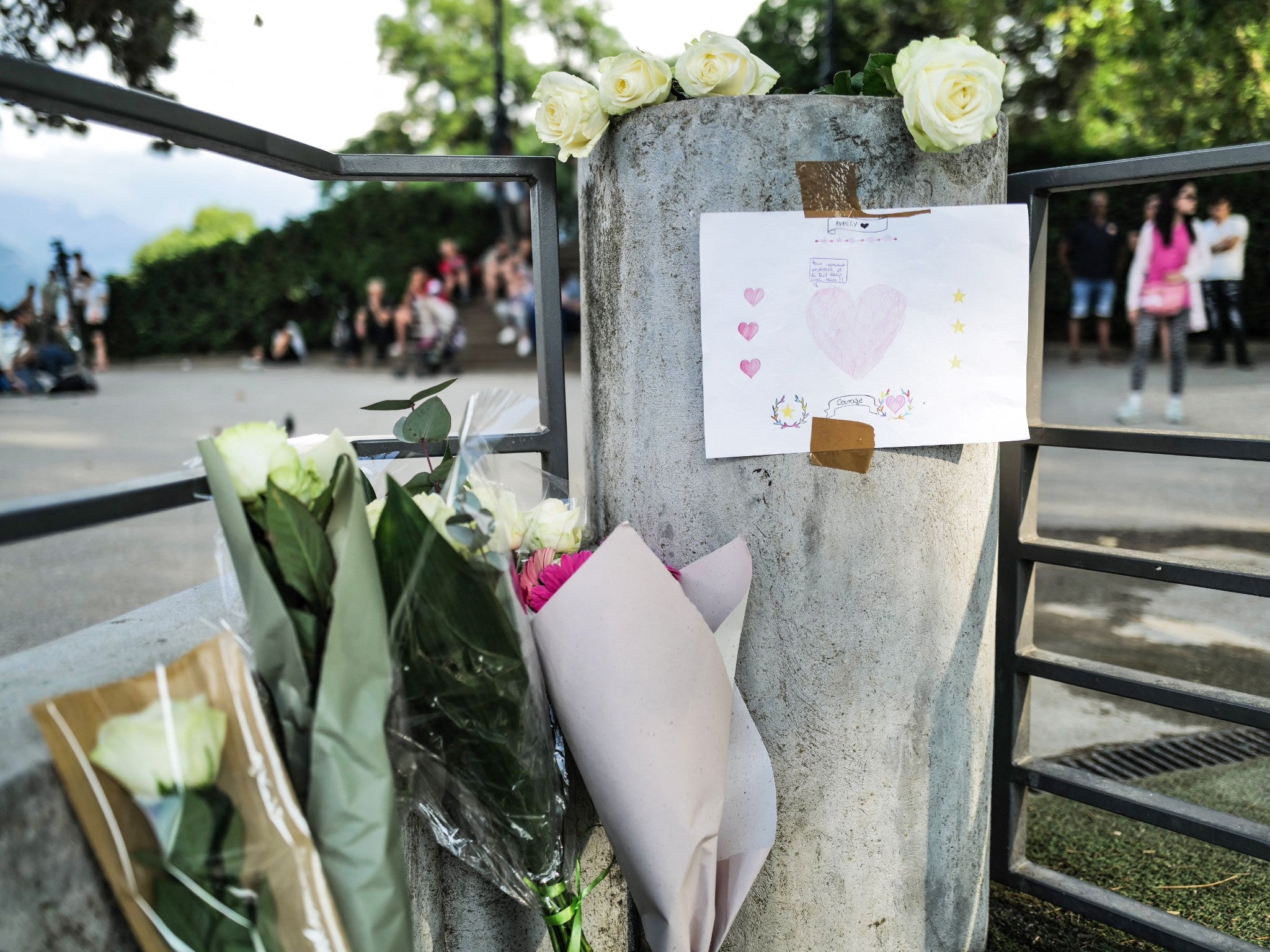 Flowers and a message for the victims are placed at a playground in Annecy