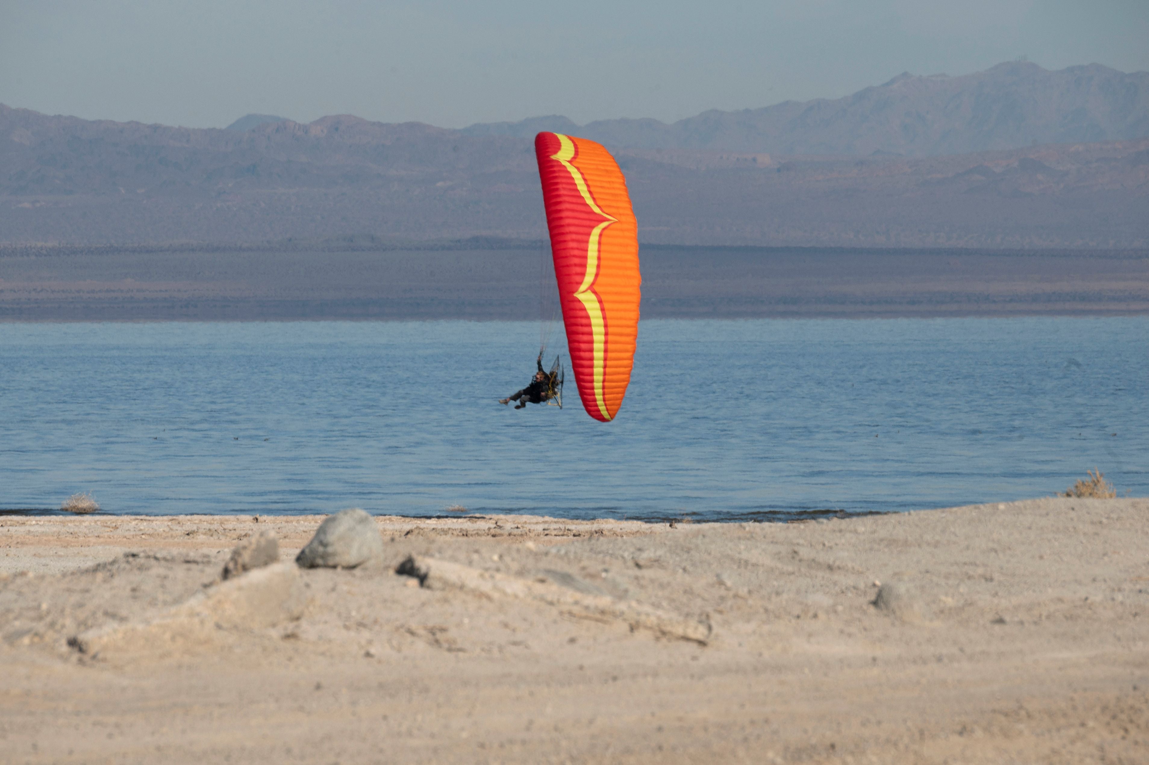 A man rides a paramotor over the Salton Sea in Salton City, California, December 16, 2021