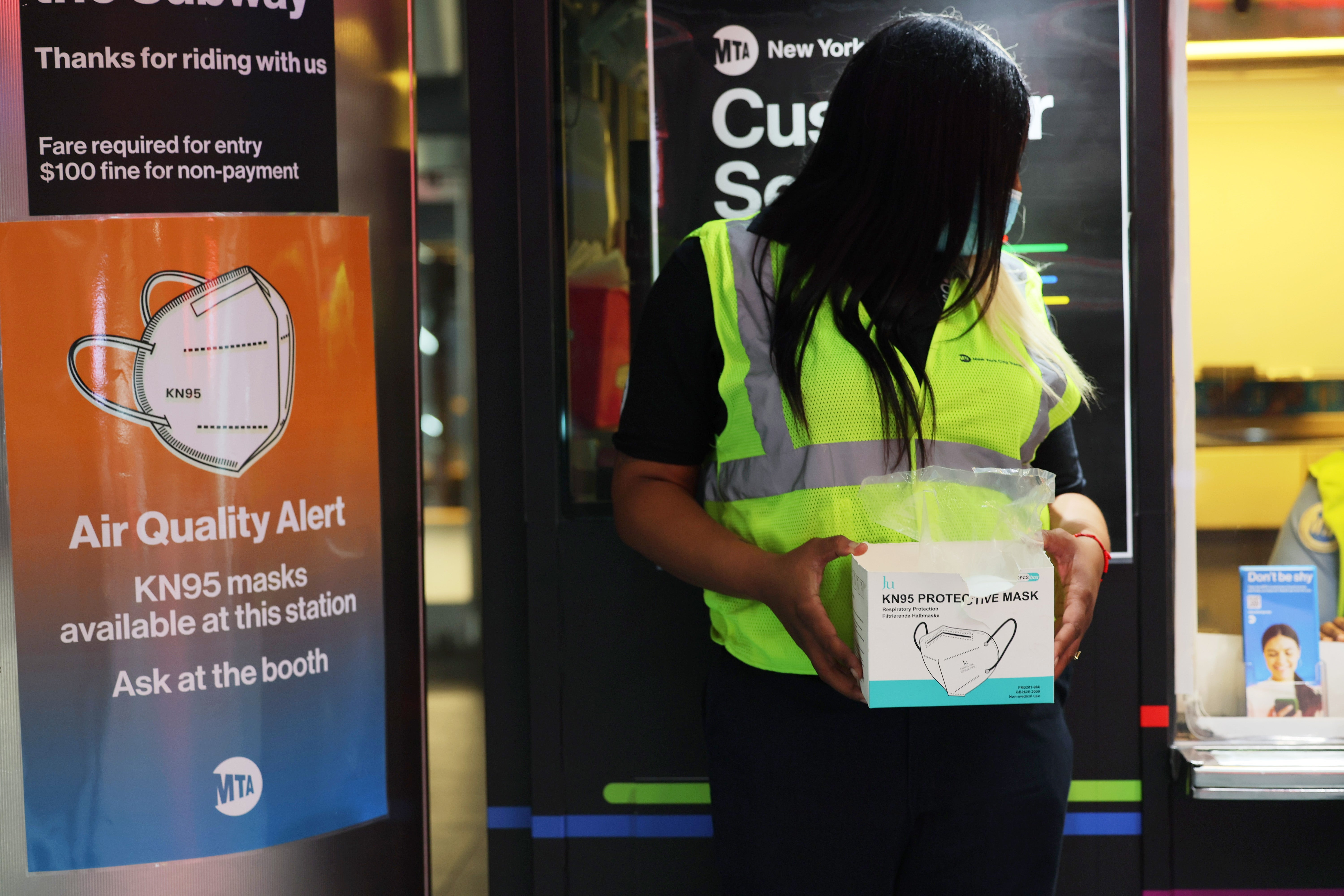 MTA employee Shanita Hancle offers masks to passengers at the Fulton Street subway station in Manhattan on 8 June