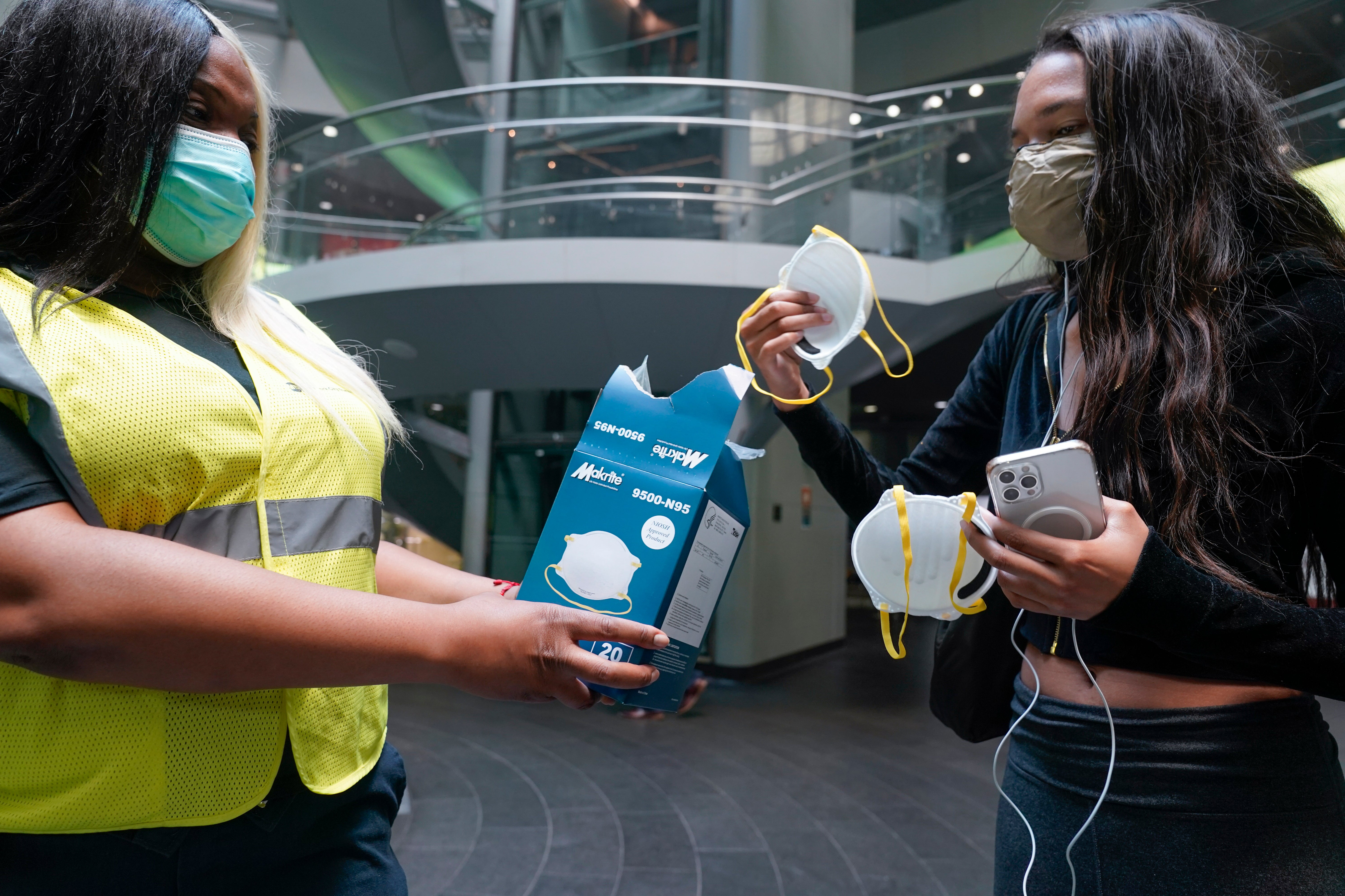 An MTA employee hands out masks outside a subway station