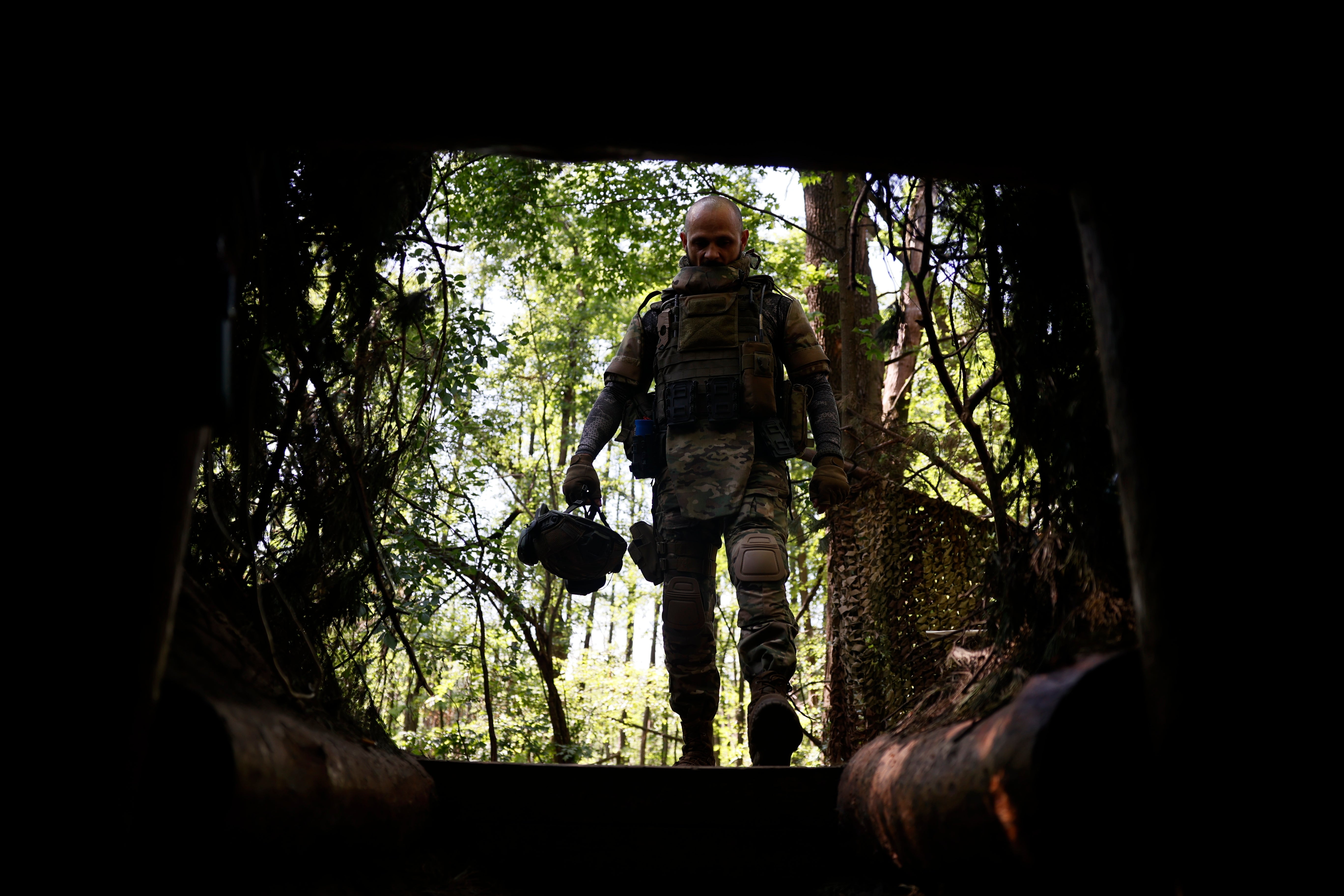 A Ukrainian soldier stands at a shelter entrance on the frontline in Luhansk region