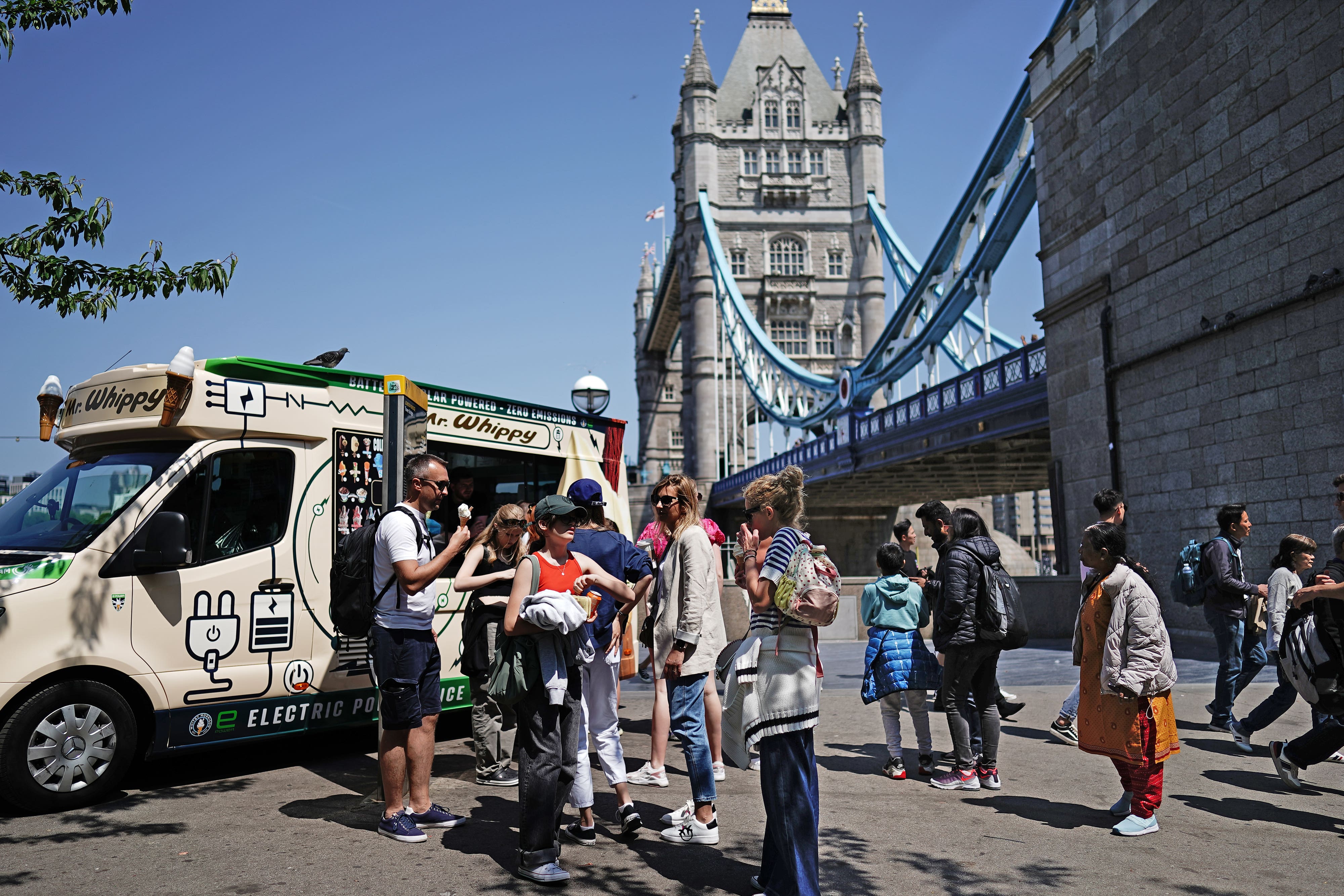 People enjoying the warm weather near Tower Bridge in London (Aaron Chown/PA)