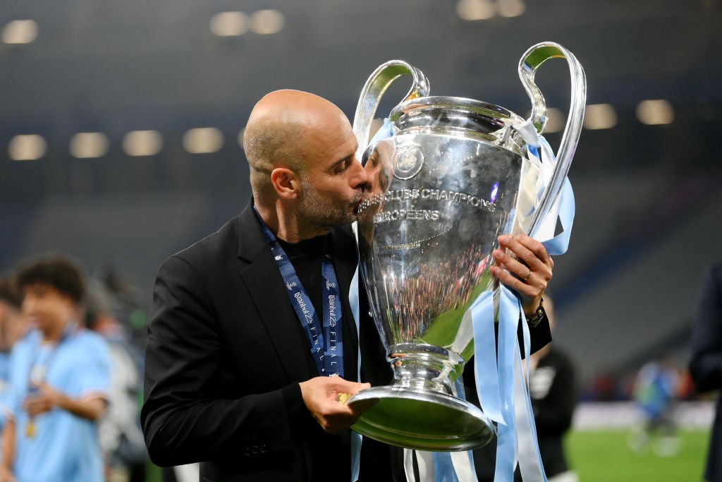 Pep Guardiola gets his hands on the trophy for the third time as a manager