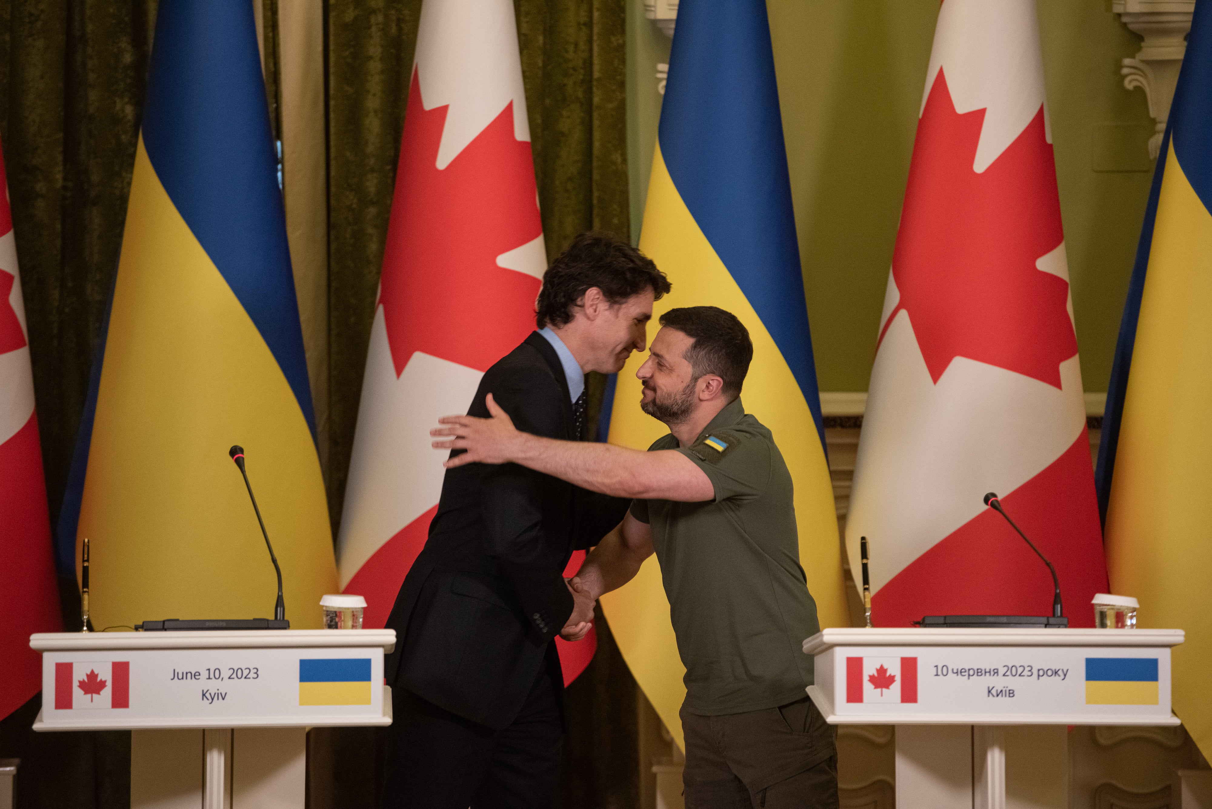 The prime minister of Canada Justin Trudeau and Ukrainian president Volodymyr Zelensky shake hands and hug