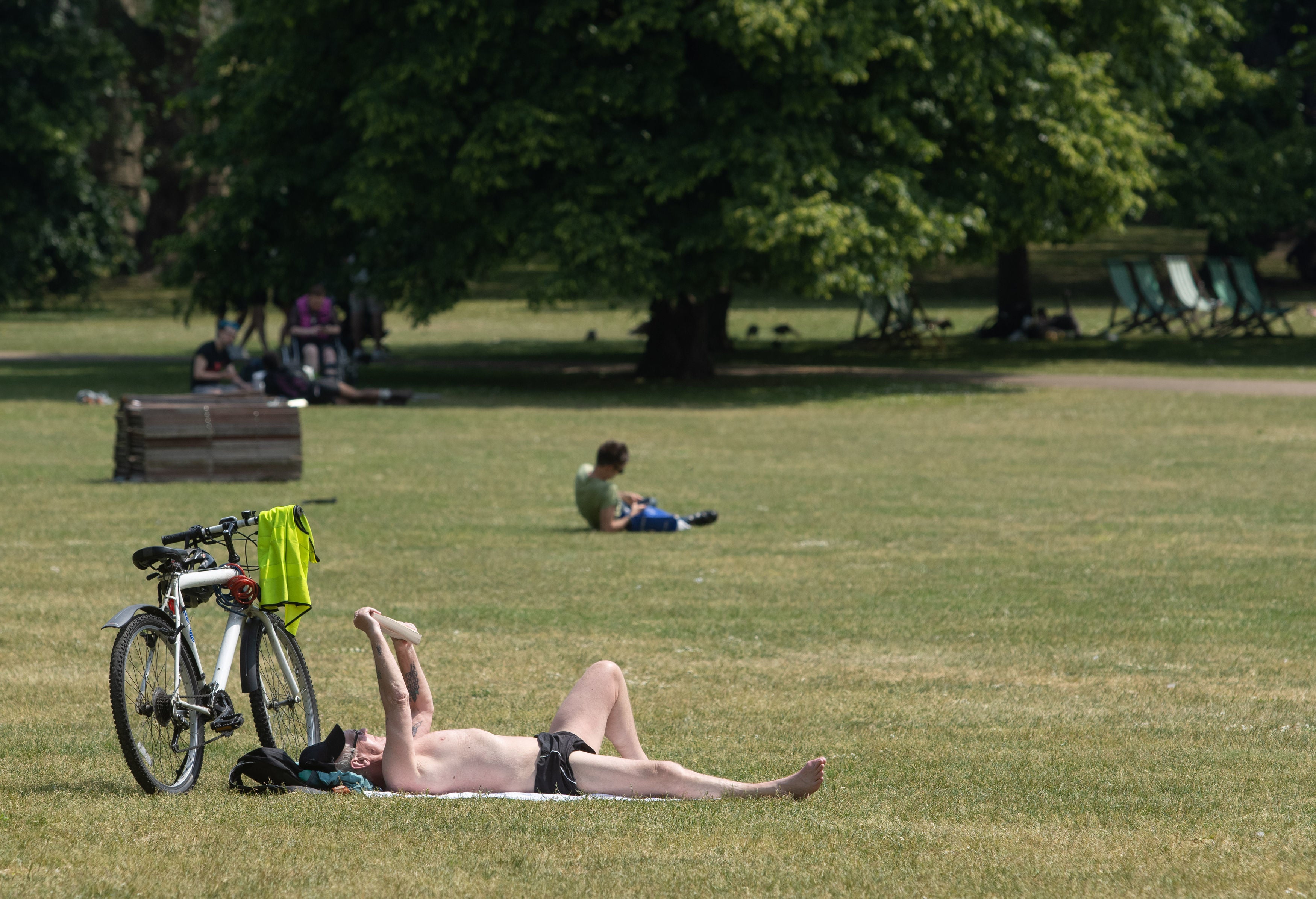 A man sunbathes at St James's Park park in central London.