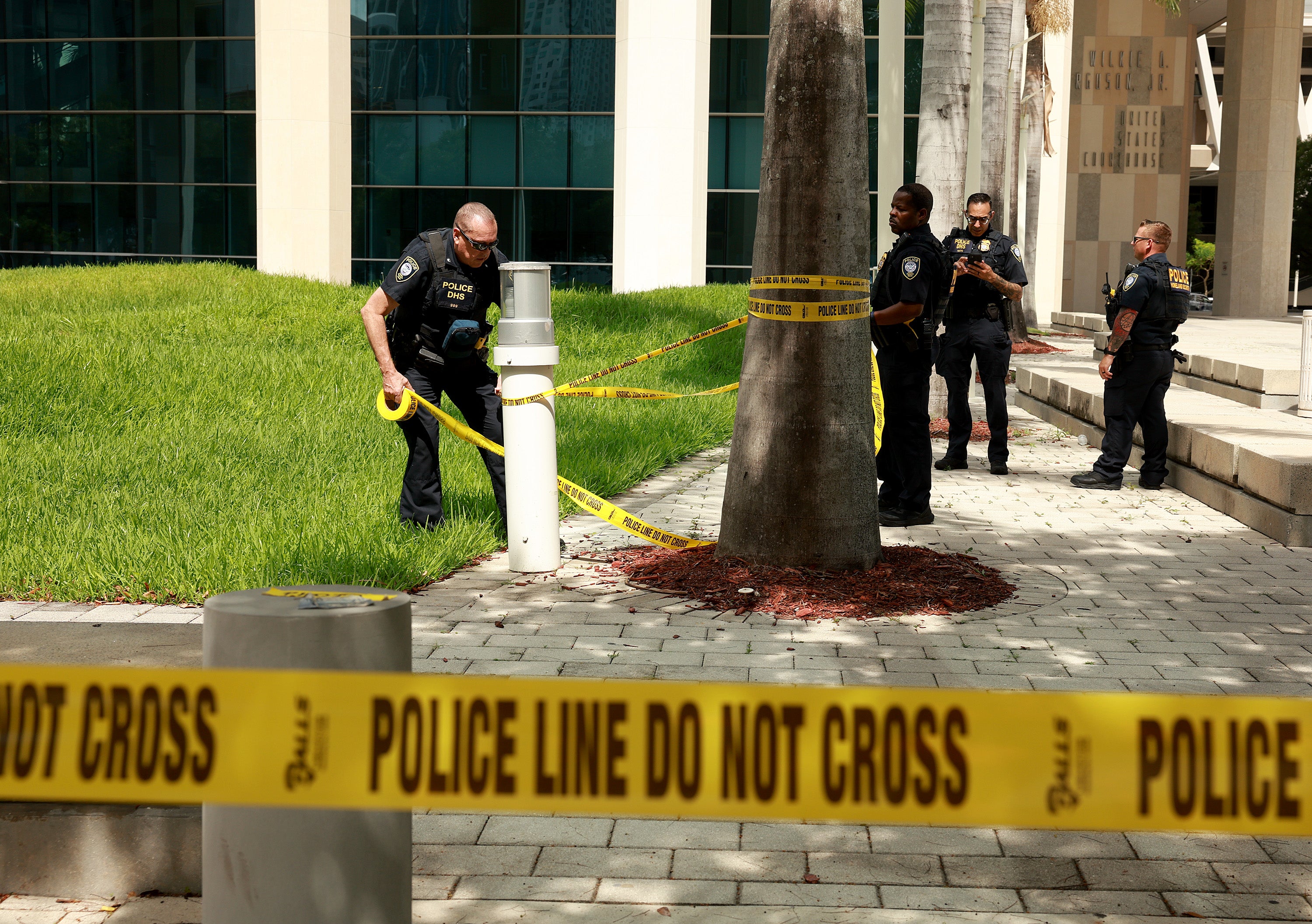 Department of Homeland Security police place tape off an area in front of the Wilkie D Ferguson Jr federal courthouse in Miami on 12 June